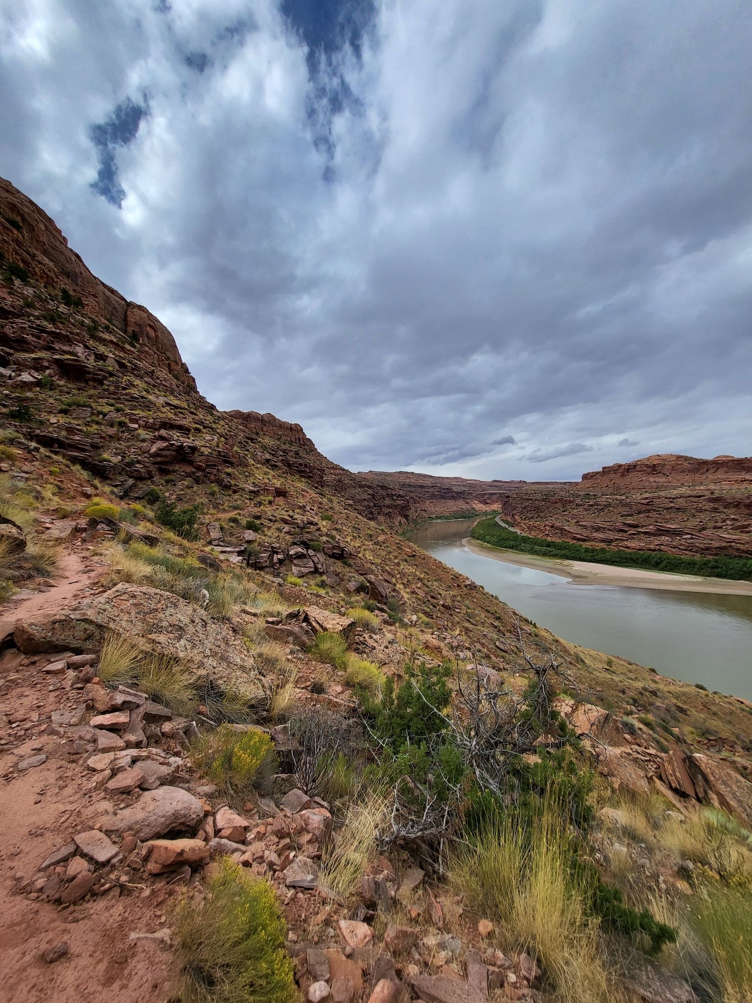 River flowing through a desert canyon with rocky slopes, cloudy sky. - Jackson Hole Loop