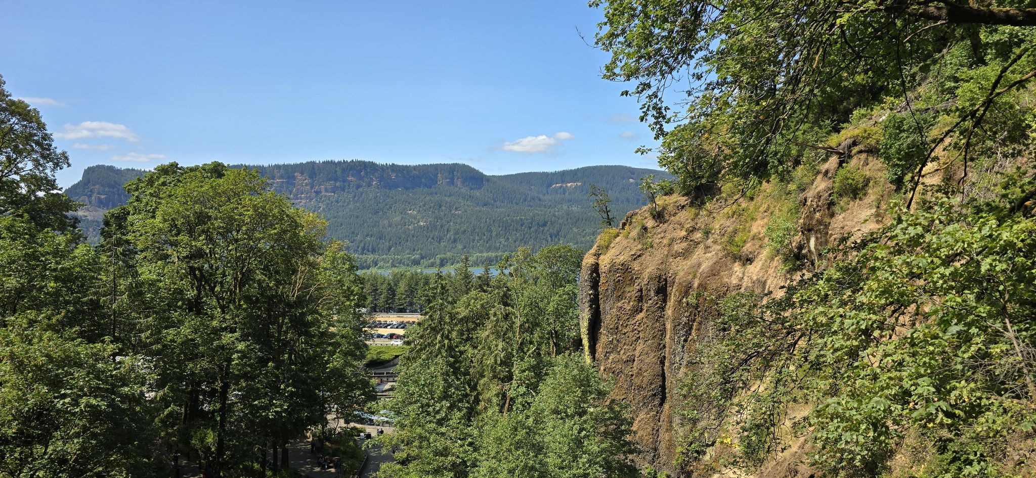 Panoramic view from a cliff of a green valley, river, and distant mountains. - Wiesendanger Falls – Multnomah Falls loop from Benson State Recreation Area