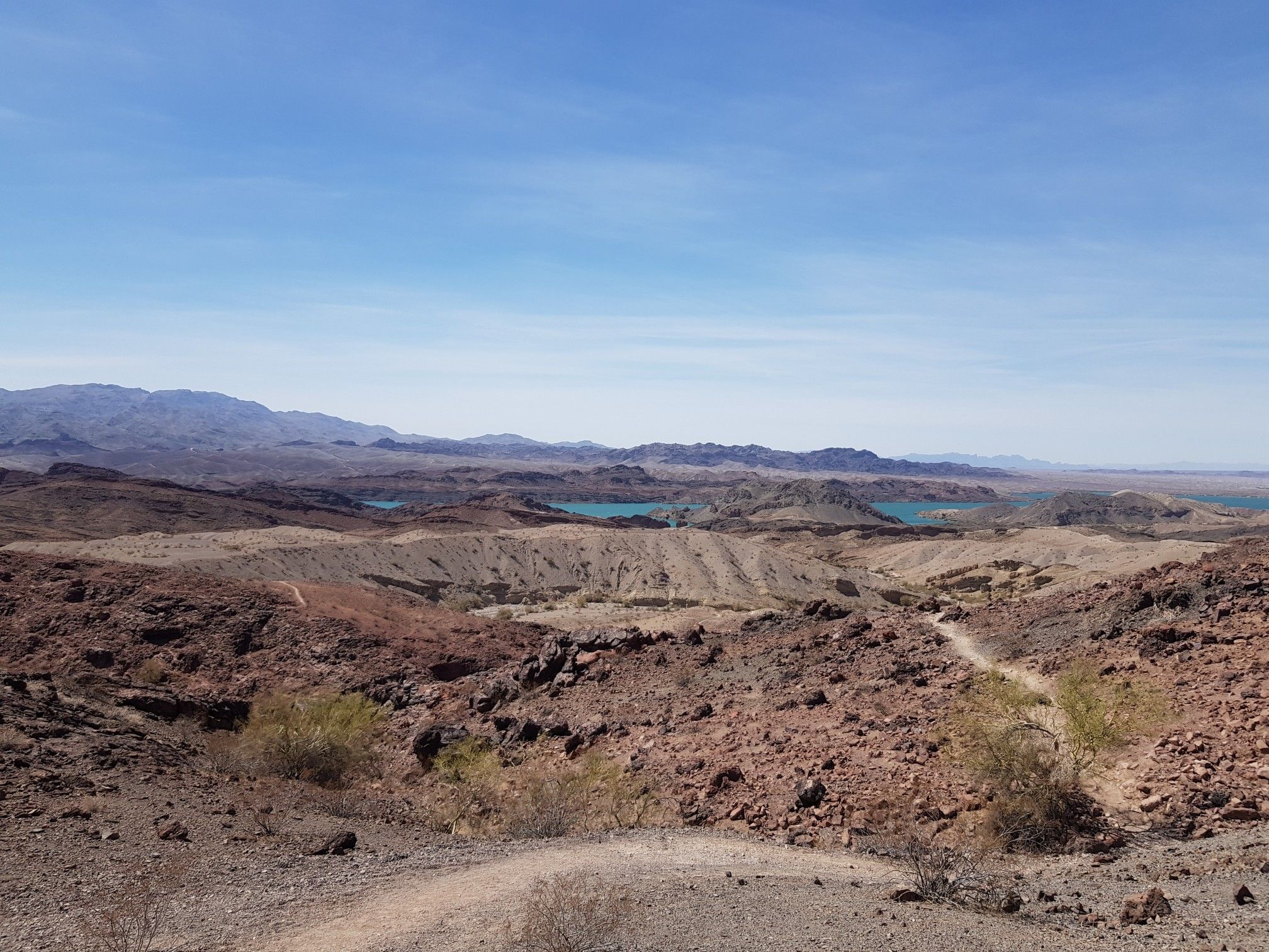 Vast desert landscape with multiple blue lakes and winding trails under clear sky. - SARA Park loop from Trailhead #1