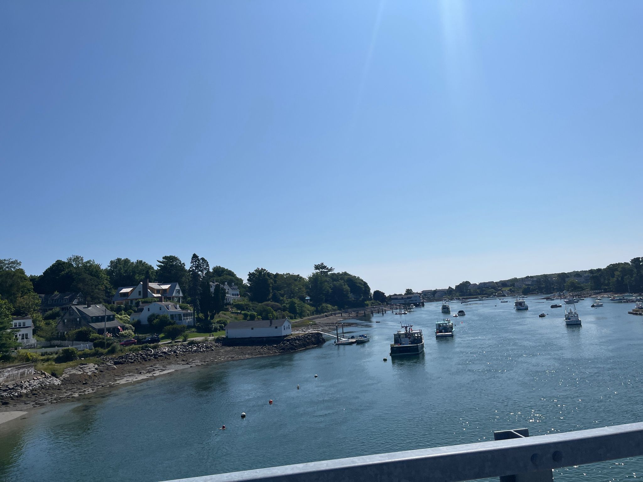 Boats in a calm waterway with houses and trees along the sunny shore. - Southside to Route 103 loop