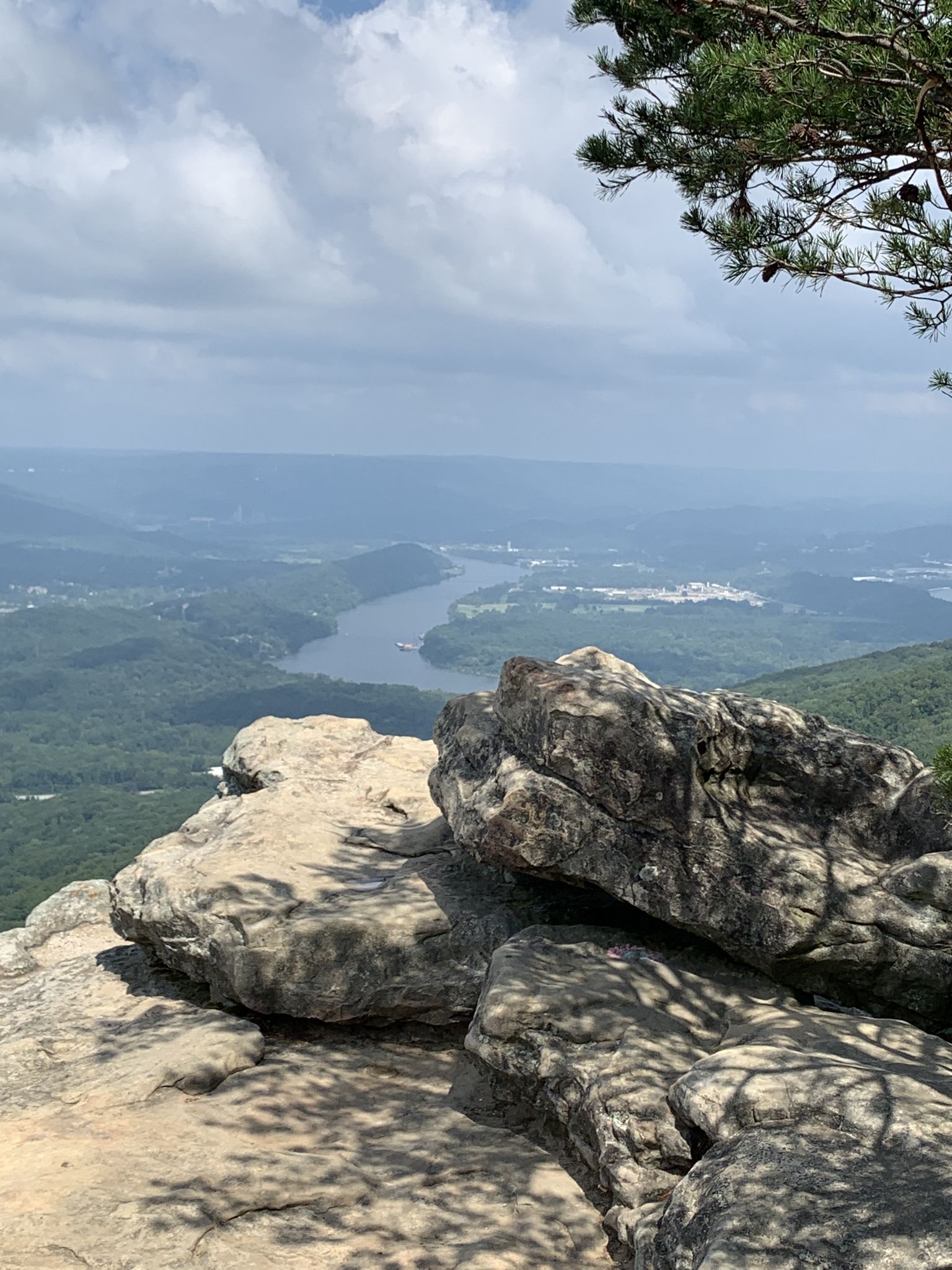 Rocky cliff edge overlooking a winding river valley under cloudy sky. - Guild Hardy Loop Trail