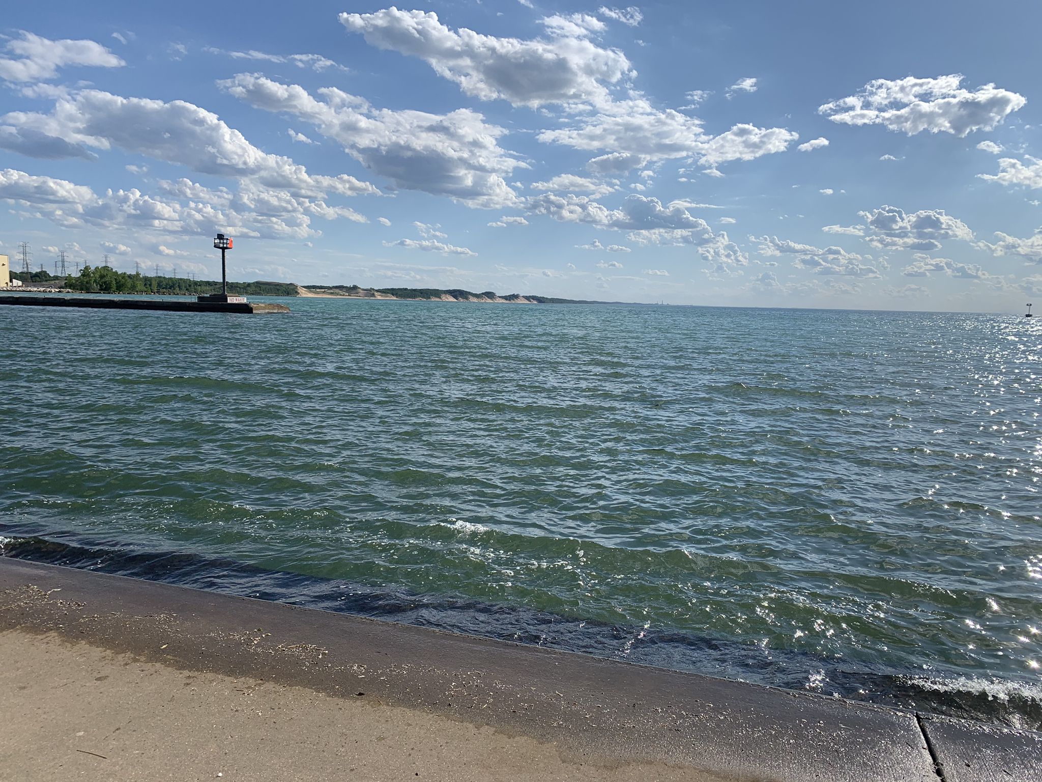 Expansive blue water under a partly cloudy sky, with a distant beacon. - Mount Baldy to Long Beach Trail