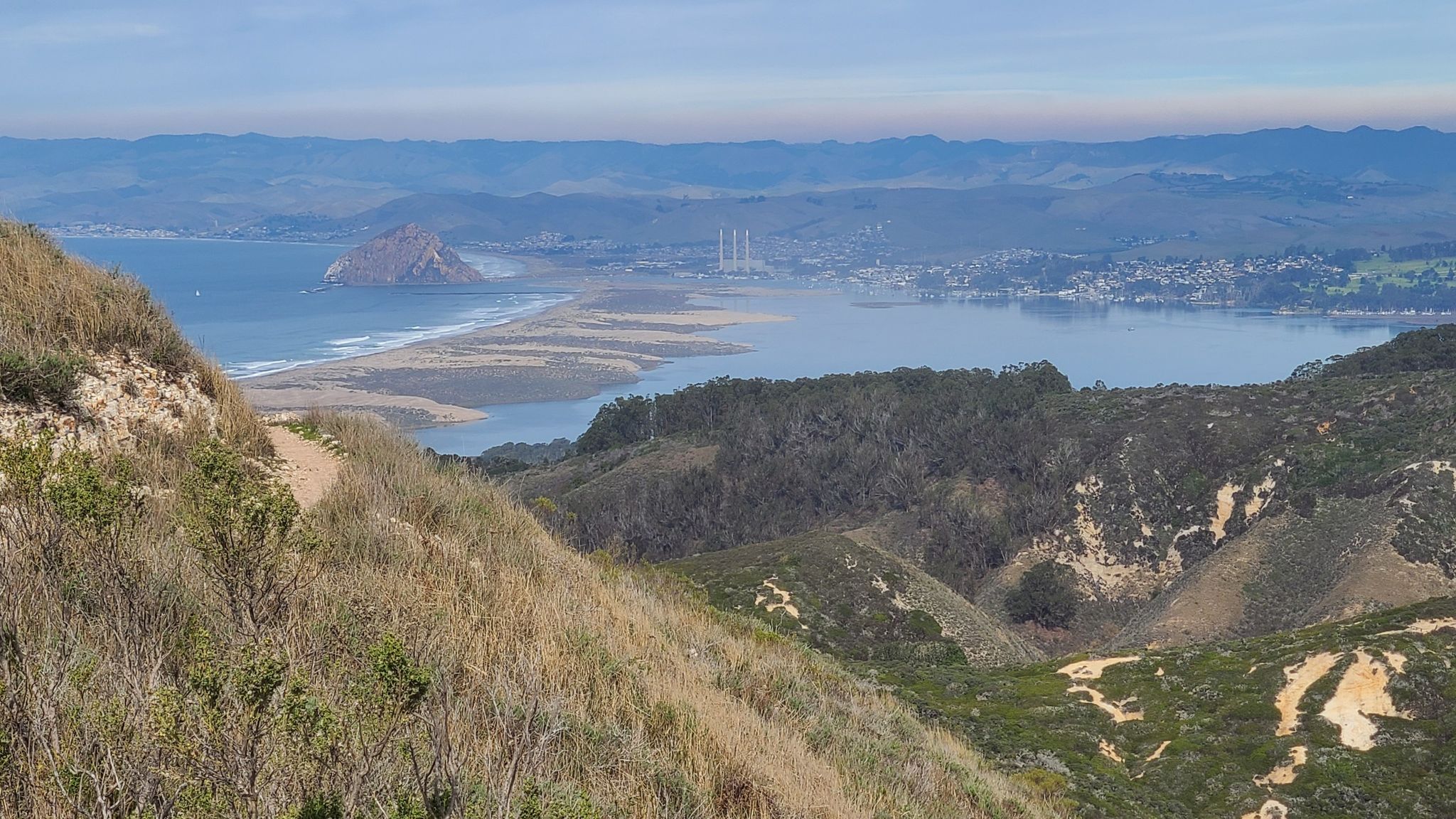 Panoramic view of a coastal bay, ocean, and a large rock under clear skies. - Spooner's Cove – Hazard Peak loop from Spooner's Cove