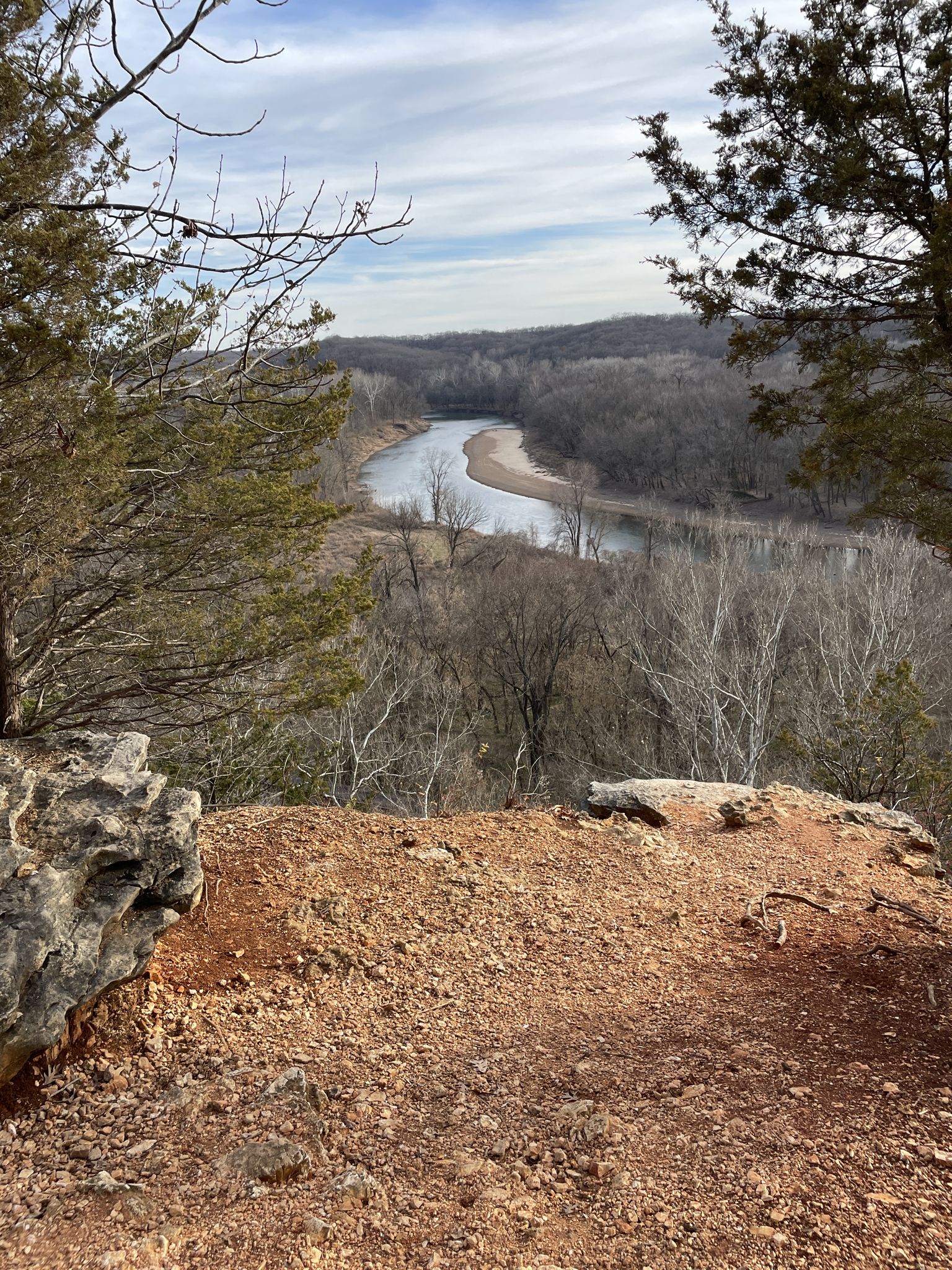 Overhead view of a winding river through a winter forest from a rocky cliff. - Grotpeter and Lone Wolf Trail Loop