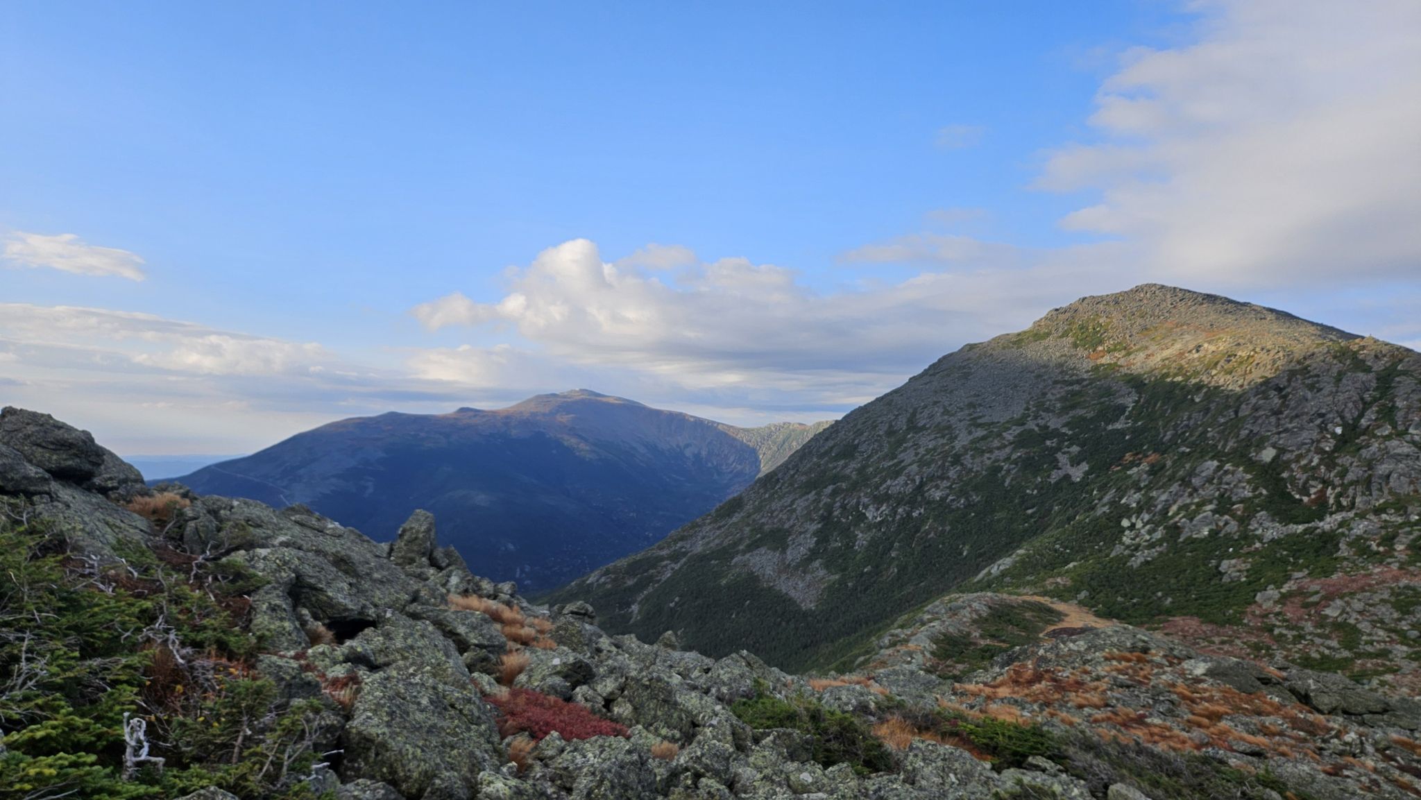 Rocky mountain landscape with two peaks under a bright, partly cloudy sky. - Valley Way Trail