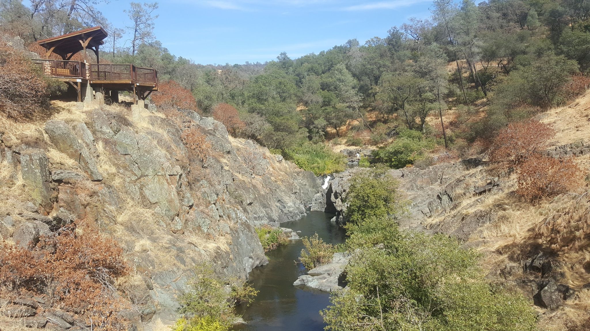 Sunny view of a river flowing through a rocky canyon with an observation deck. - Start of Creekside trail – Hidden Falls Park loop from Auburn-Conheim