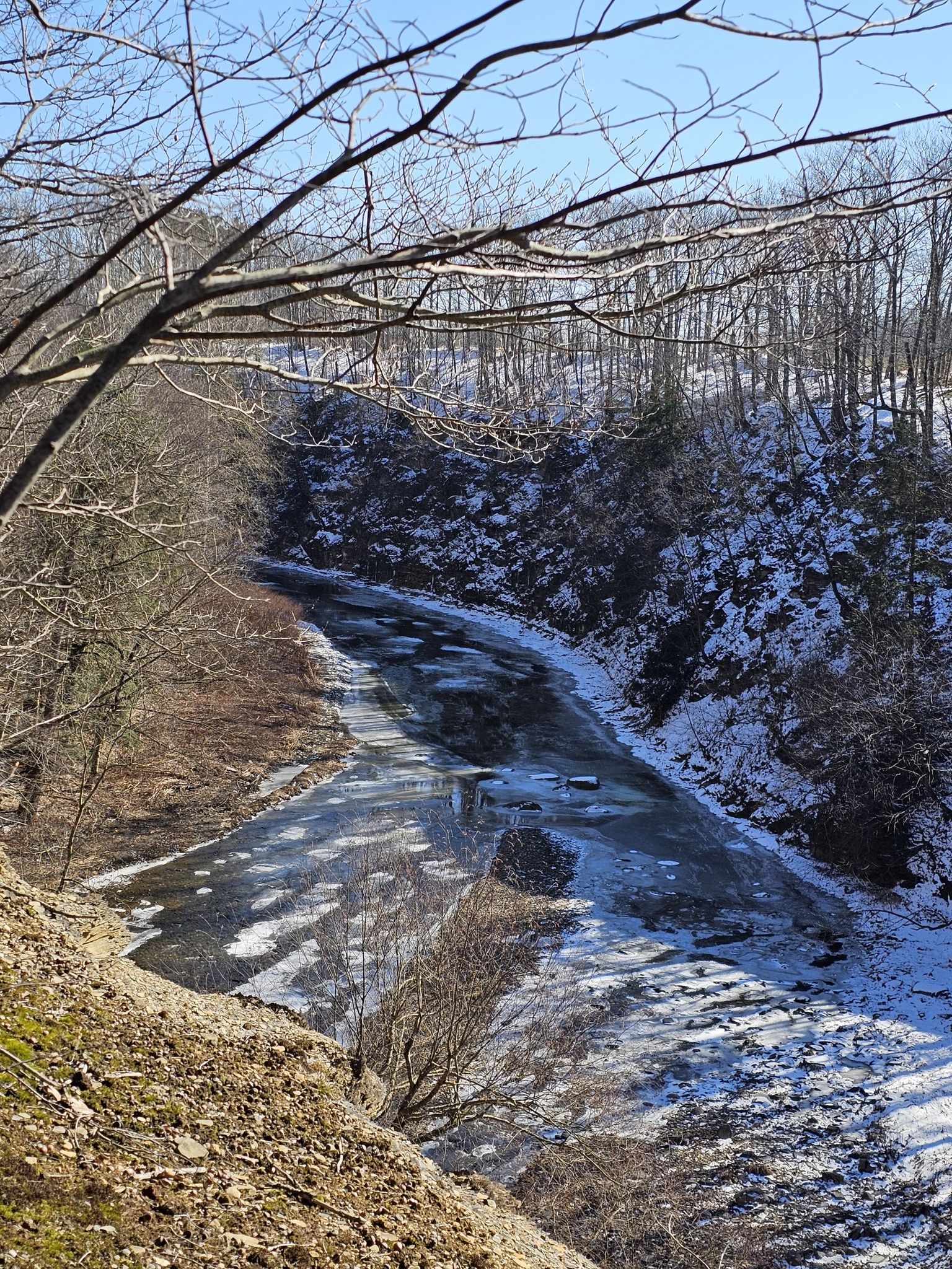 Sunny view of a partially frozen river in a snowy valley. - Gorge Rim Trail