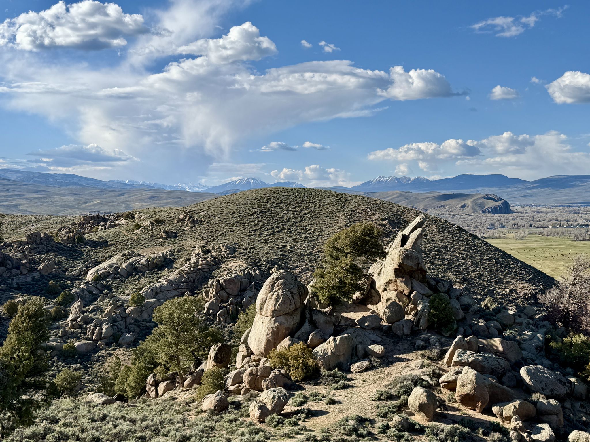 Rocky, sagebrush-covered hills under a bright, partly cloudy sky. - Hartman Rocks Loop