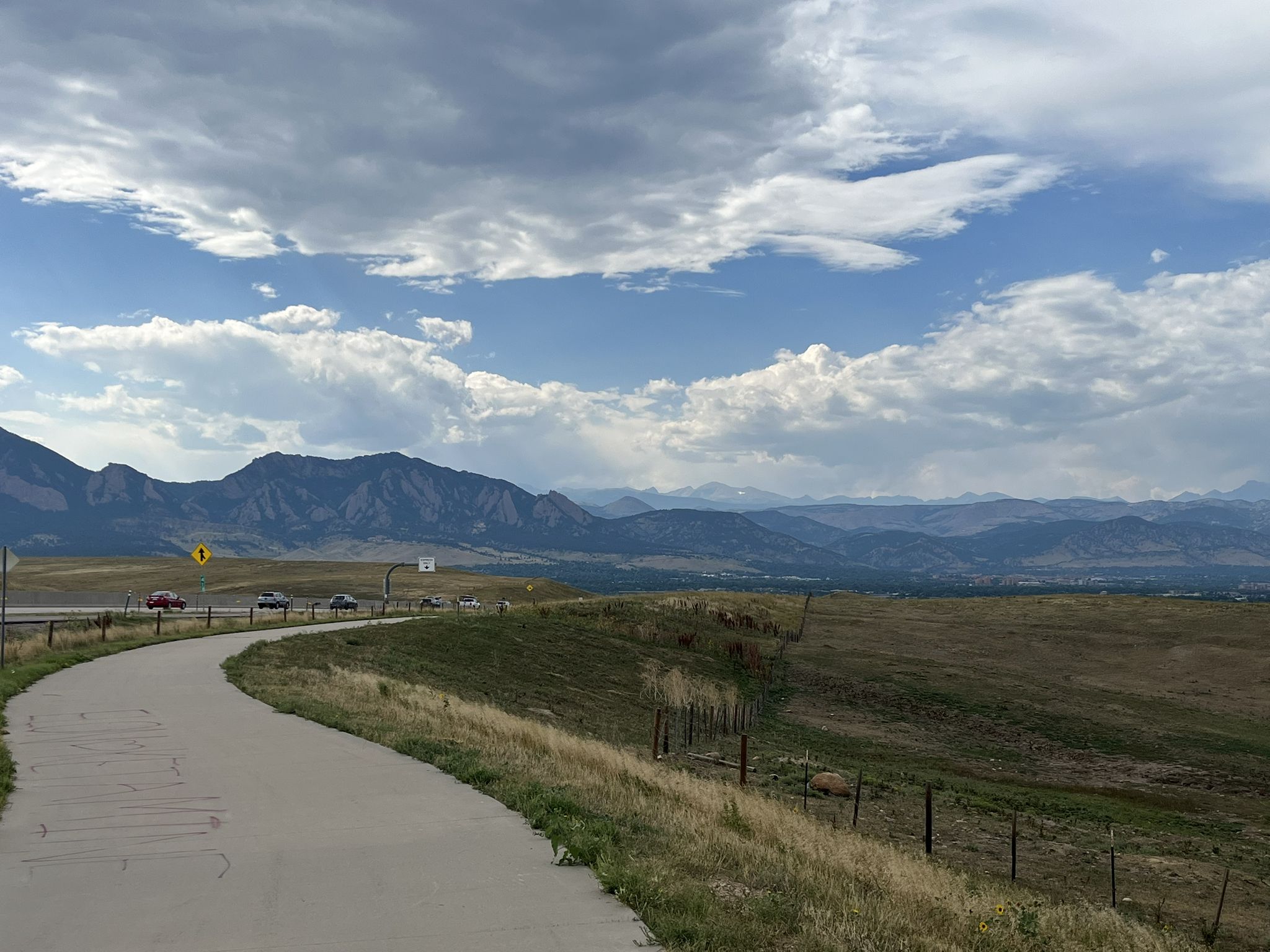 Winding paved road overlooking a valley and mountains under cloudy sky. - Davidson Mesa Overlook – Frank Varra Park Pathway loop from Visitor