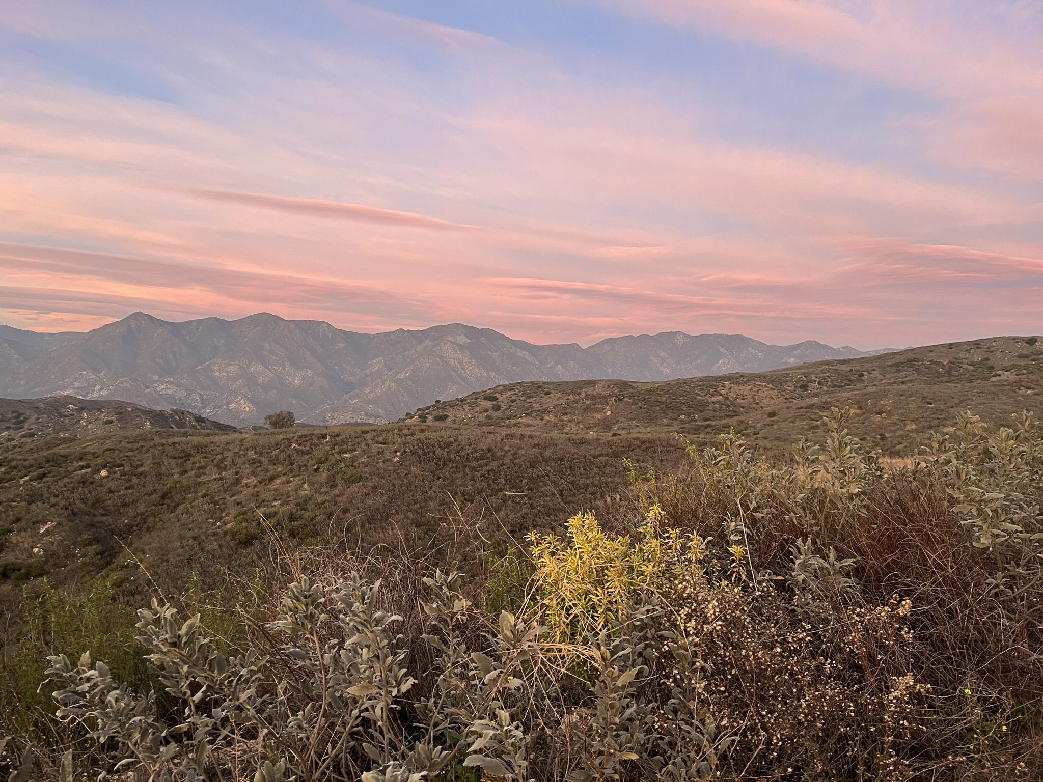 Scrubland hills and distant mountains under a beautiful pink and purple sunset sky. - Flat Discovery – Dillon Divide loop from Burbank Airport–South