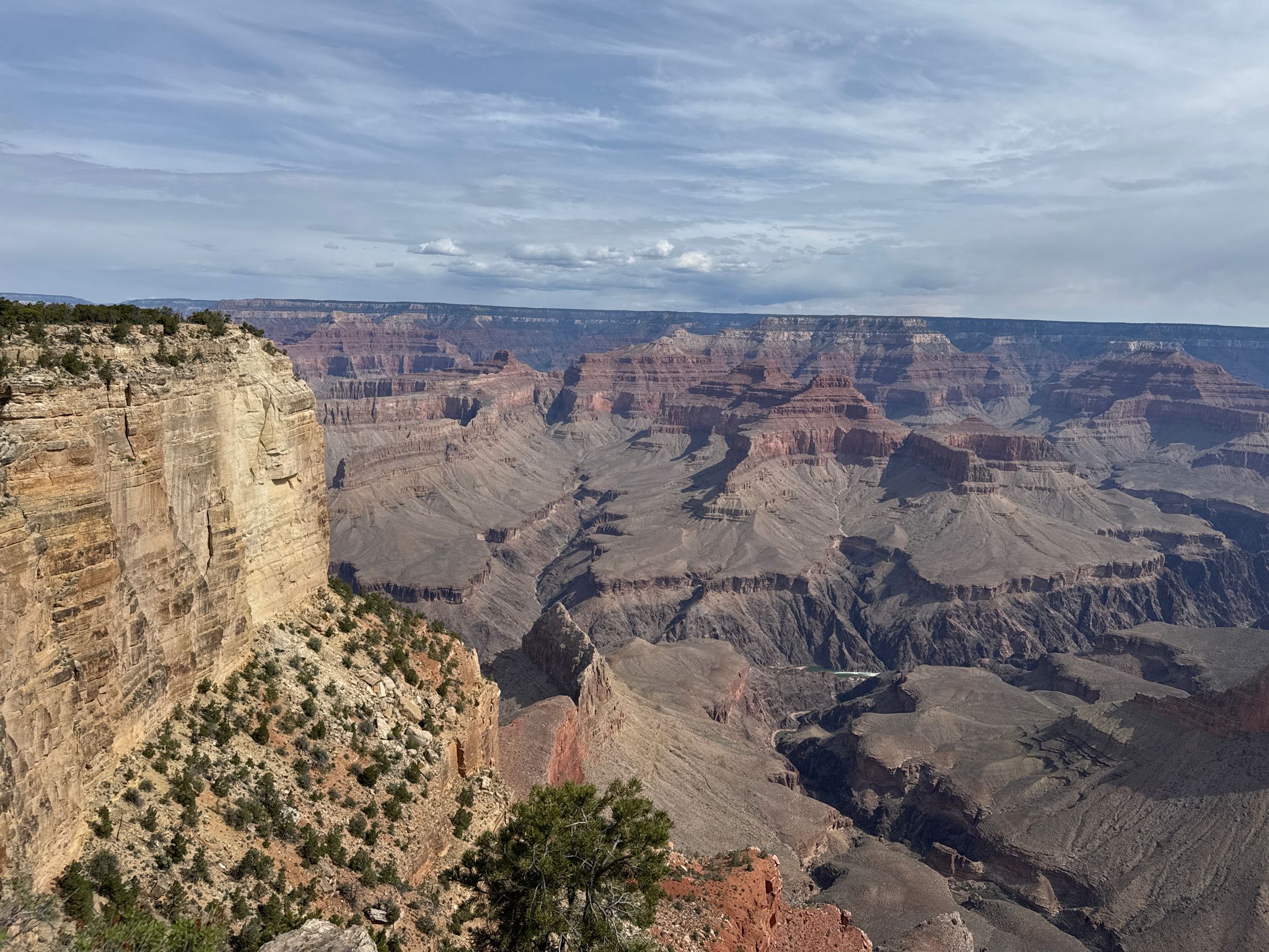 Vast, layered canyon under a partly cloudy sky, with sparse vegetation. - Bright Angel Trailhead – Hopi Point viewpoint loop from Grand Canyon