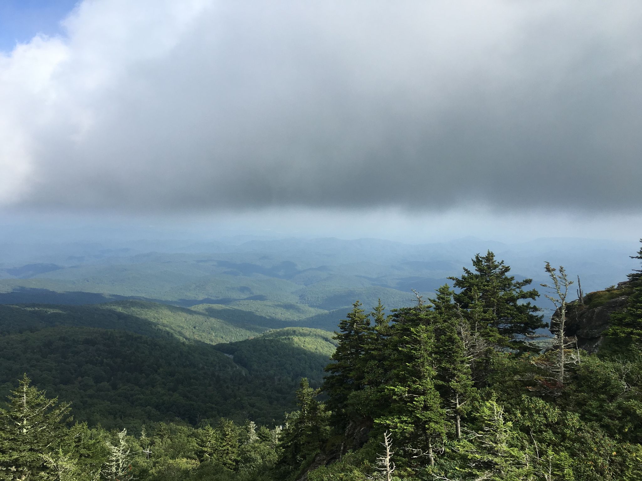 Overcast sky above a vast expanse of green, forested mountains. - Mile High Swinging Bridge loop from Grandfather Mountain