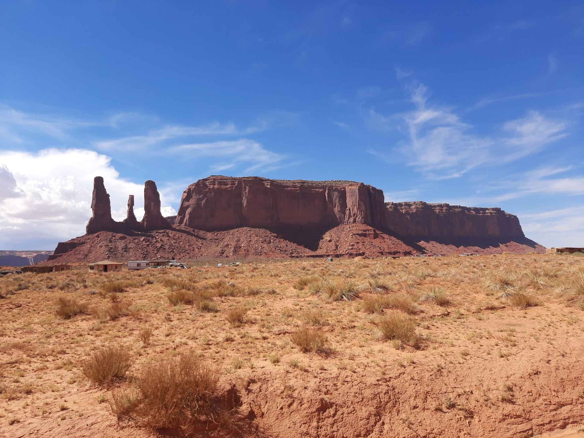 Wide desert view with distant red rock formations under a partly cloudy blue sky. - Camel Butte and Three Sisters loop