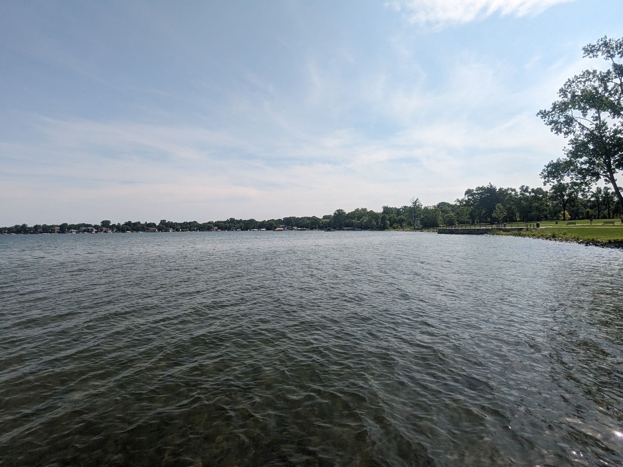 Wide view of a large lake with a distant treeline under a bright sky. - Walled Lake loop
