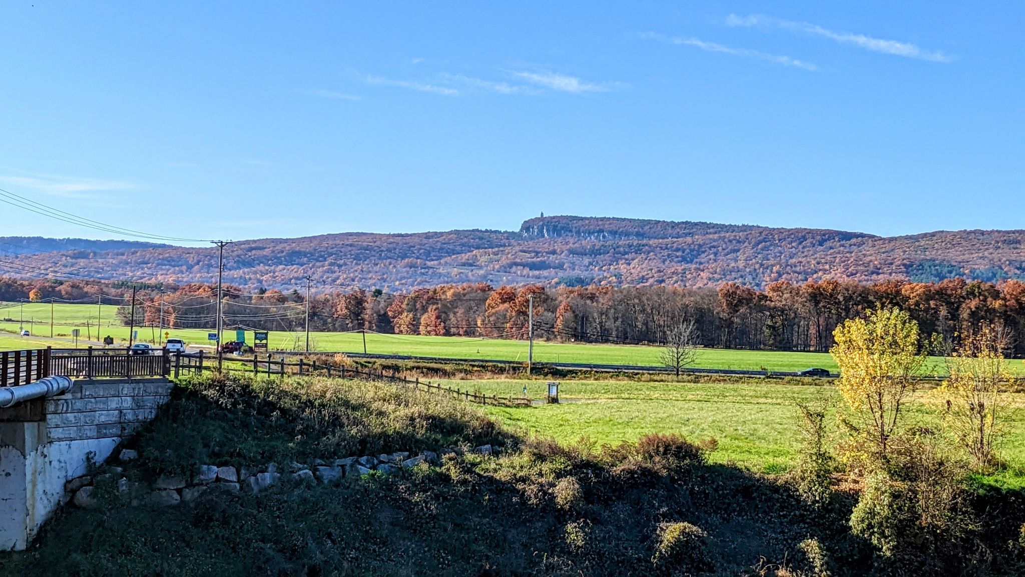 Expansive green fields and autumn trees under a bright blue sky. - River-to-Ridge Trail