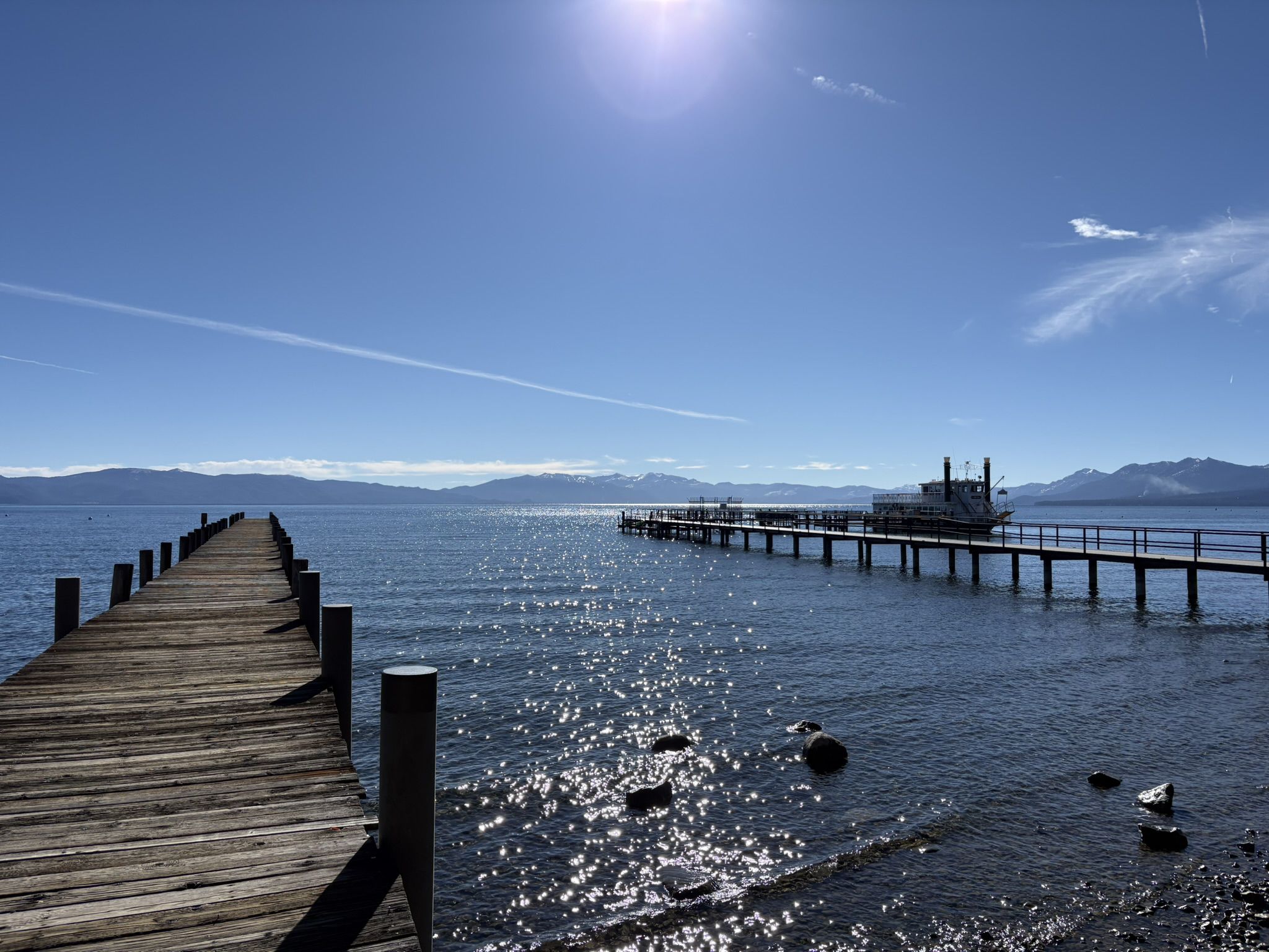Long wooden pier extending into sparkling water under a bright, sunny sky. - Tahoe City Marina loop from Burton Creek State Park