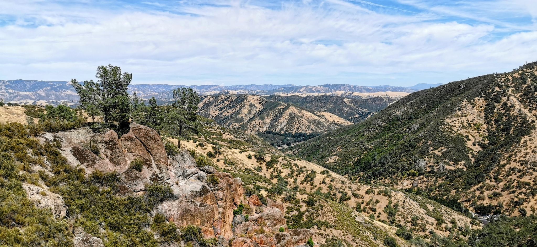 Panoramic view of a rugged, hilly landscape under a partly cloudy sky. - Condor Gulch to High Peaks Loop