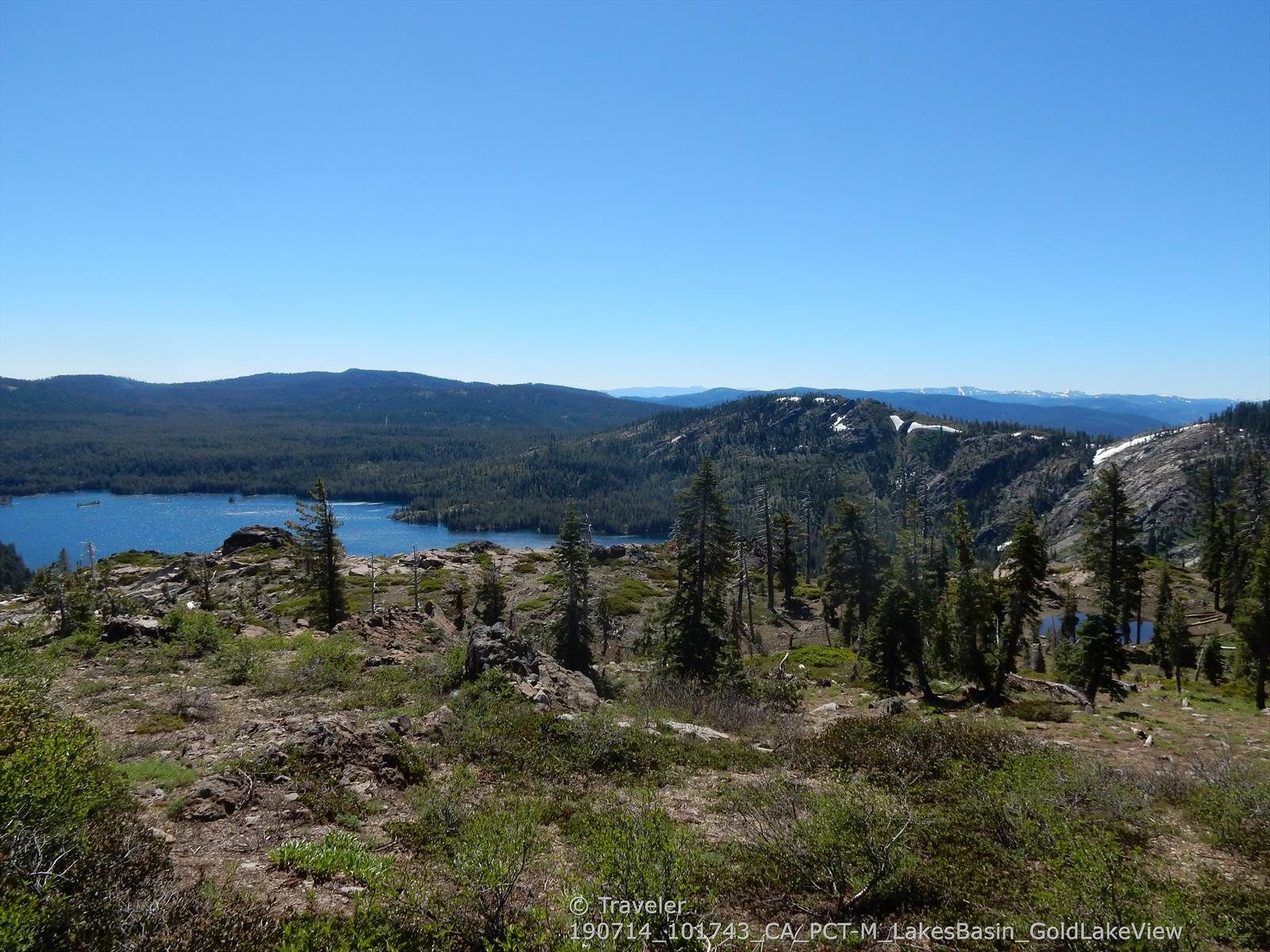 Panoramic view of a blue lake, dense forests, and distant mountains under clear sky. - Bear Lakes and Round Lake Loop
