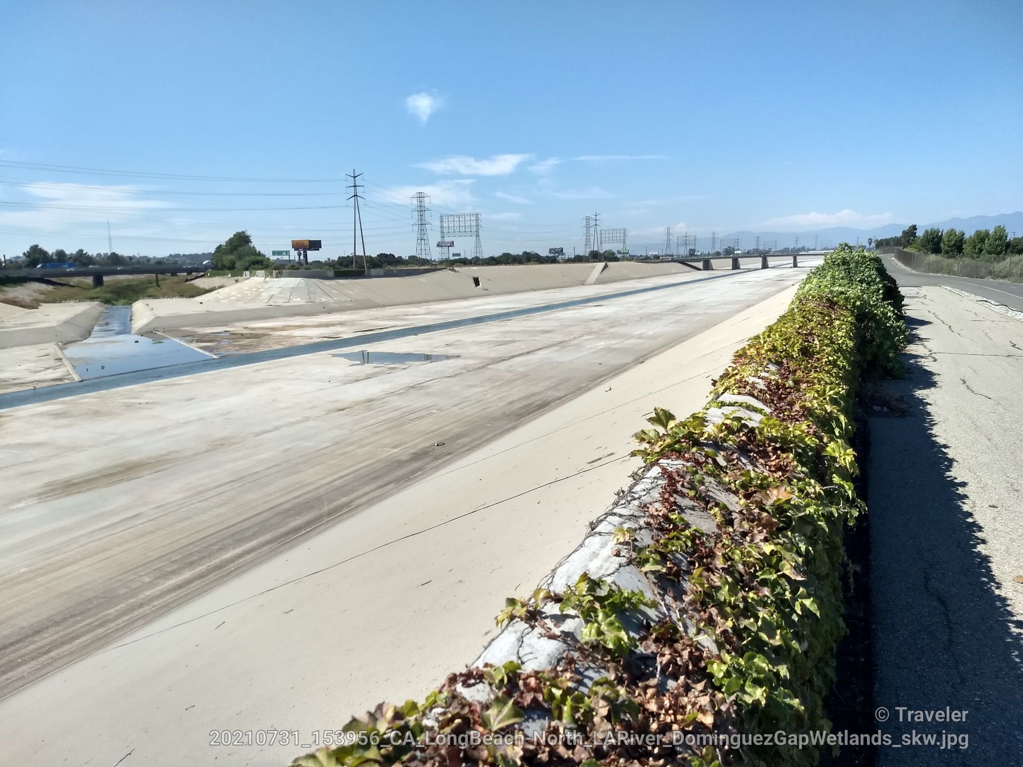 Wide concrete channel with green ivy on a wall, under a clear blue sky. - Los Angeles River Bikeway – Los Angeles River Bike Trail loop from Cudahy