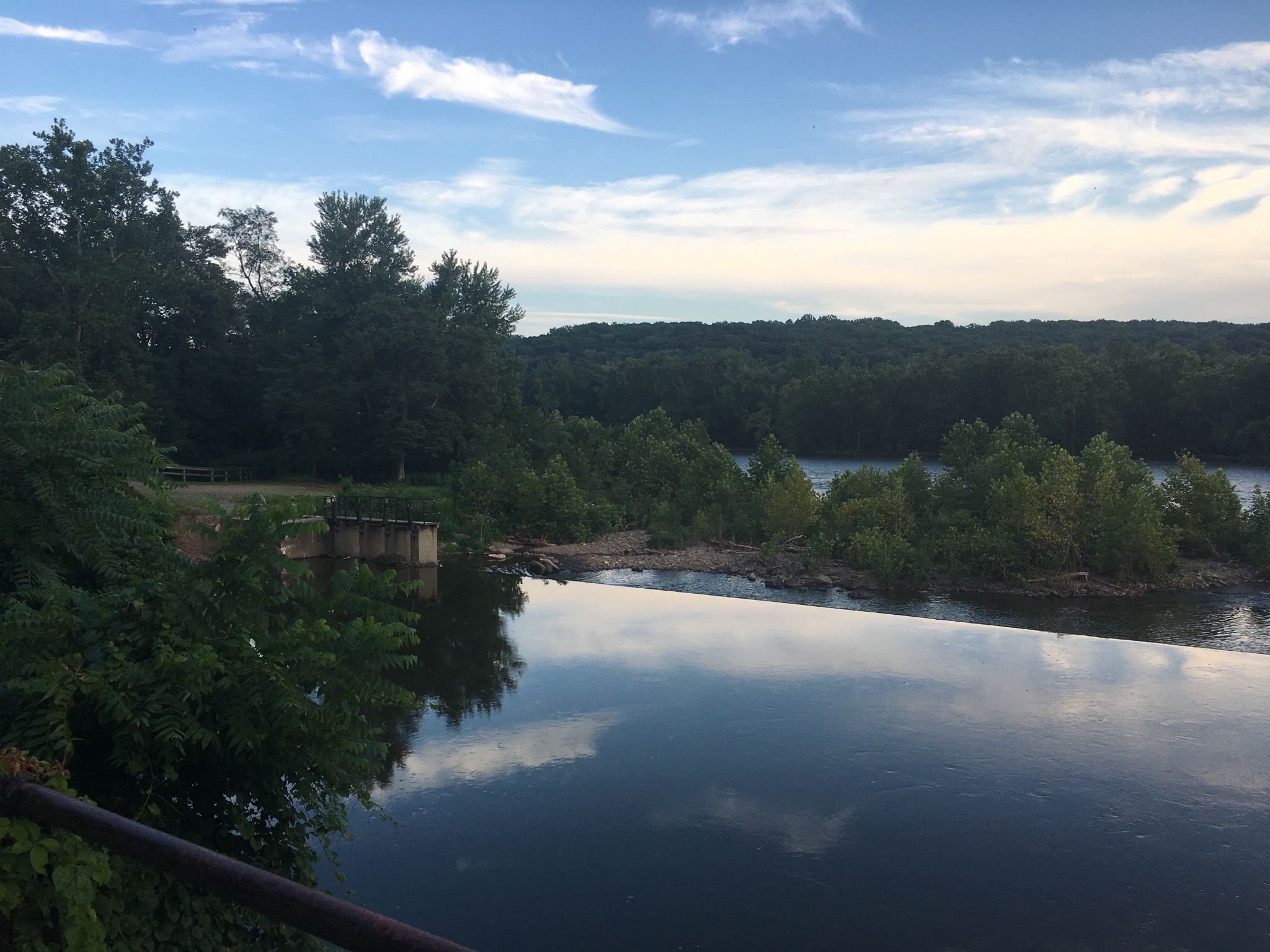 A wide river reflects the evening sky, surrounded by dense forests. - New Hope-Lambertville Bridge – Stockton Inn loop from Ted Stiles Preserve at Baldpate Mountain
