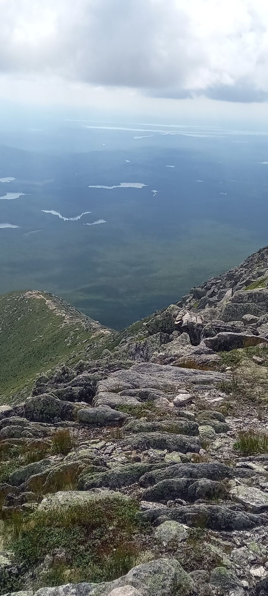 Rocky mountain slope overlooking a vast valley with lakes under cloudy sky. - Baxter Peak via Abol, Saddle, and Hunt Trail Loop