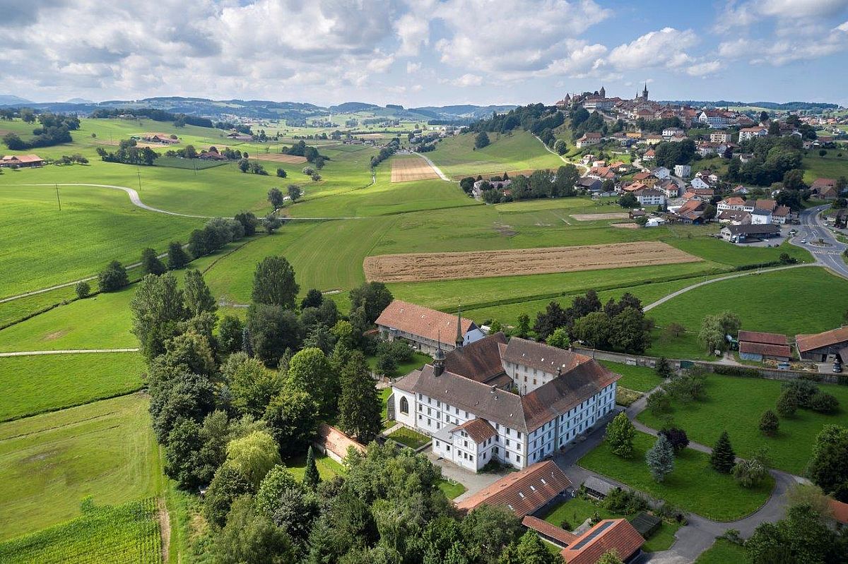 Luftaufnahme der Abtei. Bilddownload von https://fille-dieu.ch/la-communaute Im Hintergrund die Altstadt von Romont