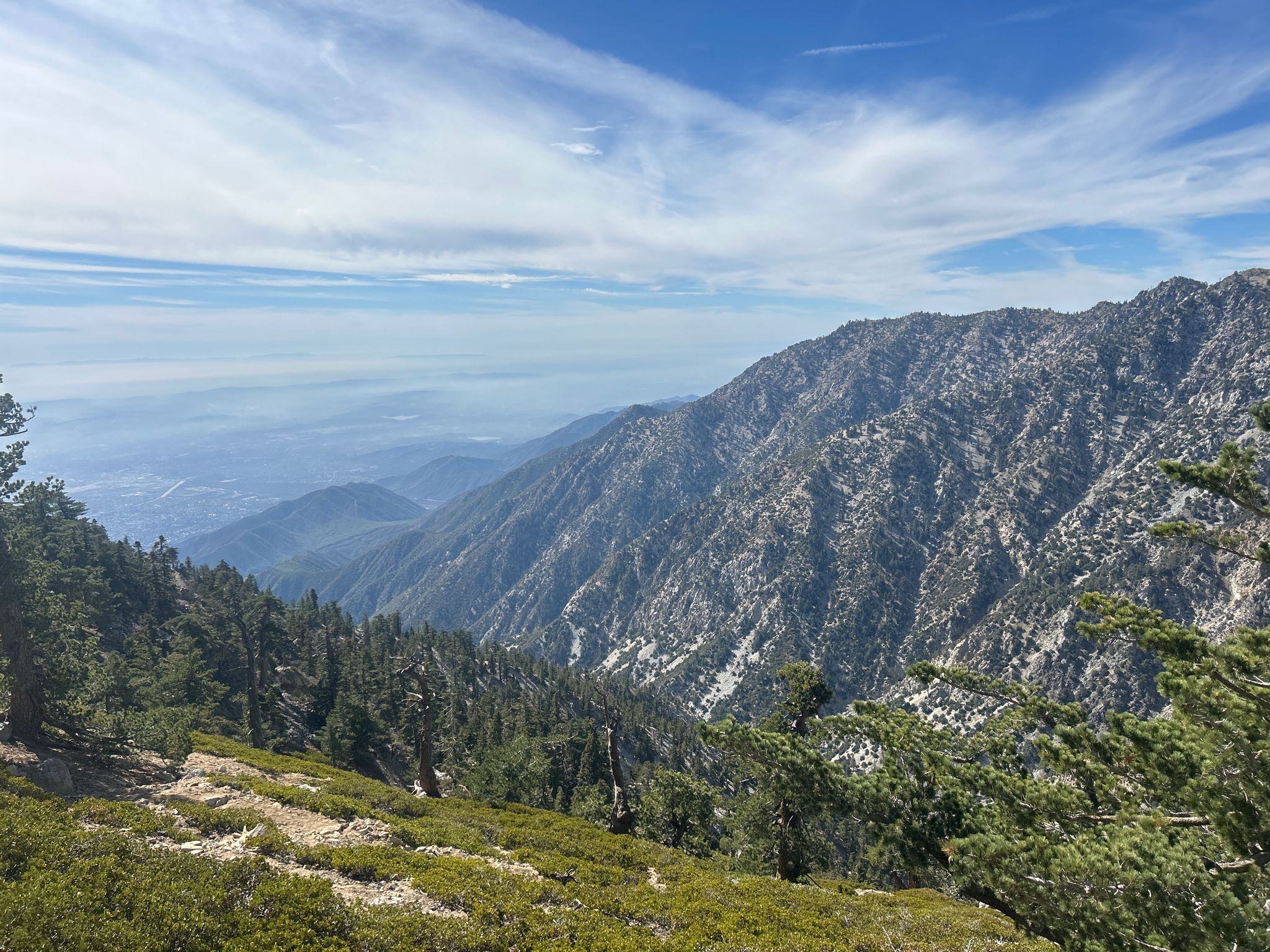 Expansive mountain range view with a hazy valley below. - Icehouse Saddle – Cucamonga Peak loop from Icehouse Canyon Trailhead