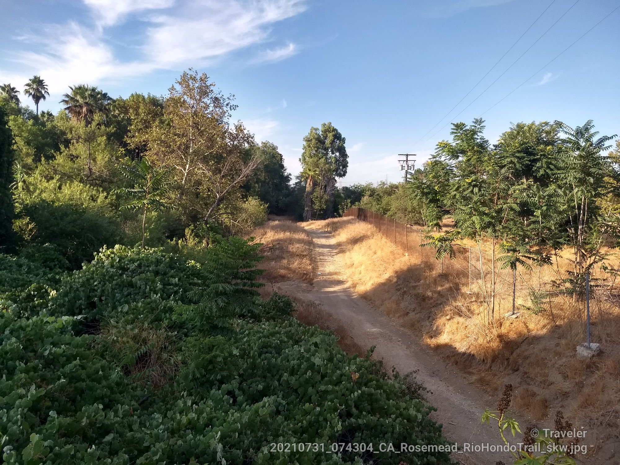 A winding dirt path through green and dry brush under a bright sky. - Rio Hondo River Trail