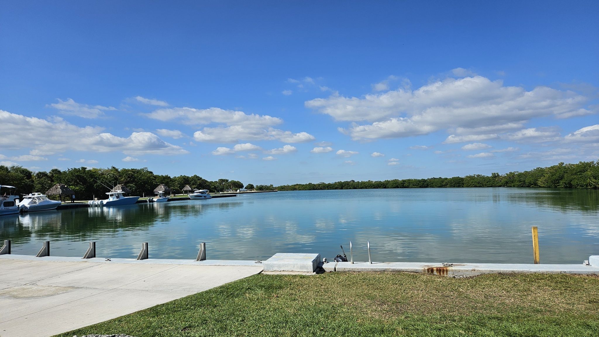Calm blue water with boats docked, surrounded by green trees. - No Name Harbor – Biscayne Bay Viewpoint loop from Bill Baggs Cape Florida State Park