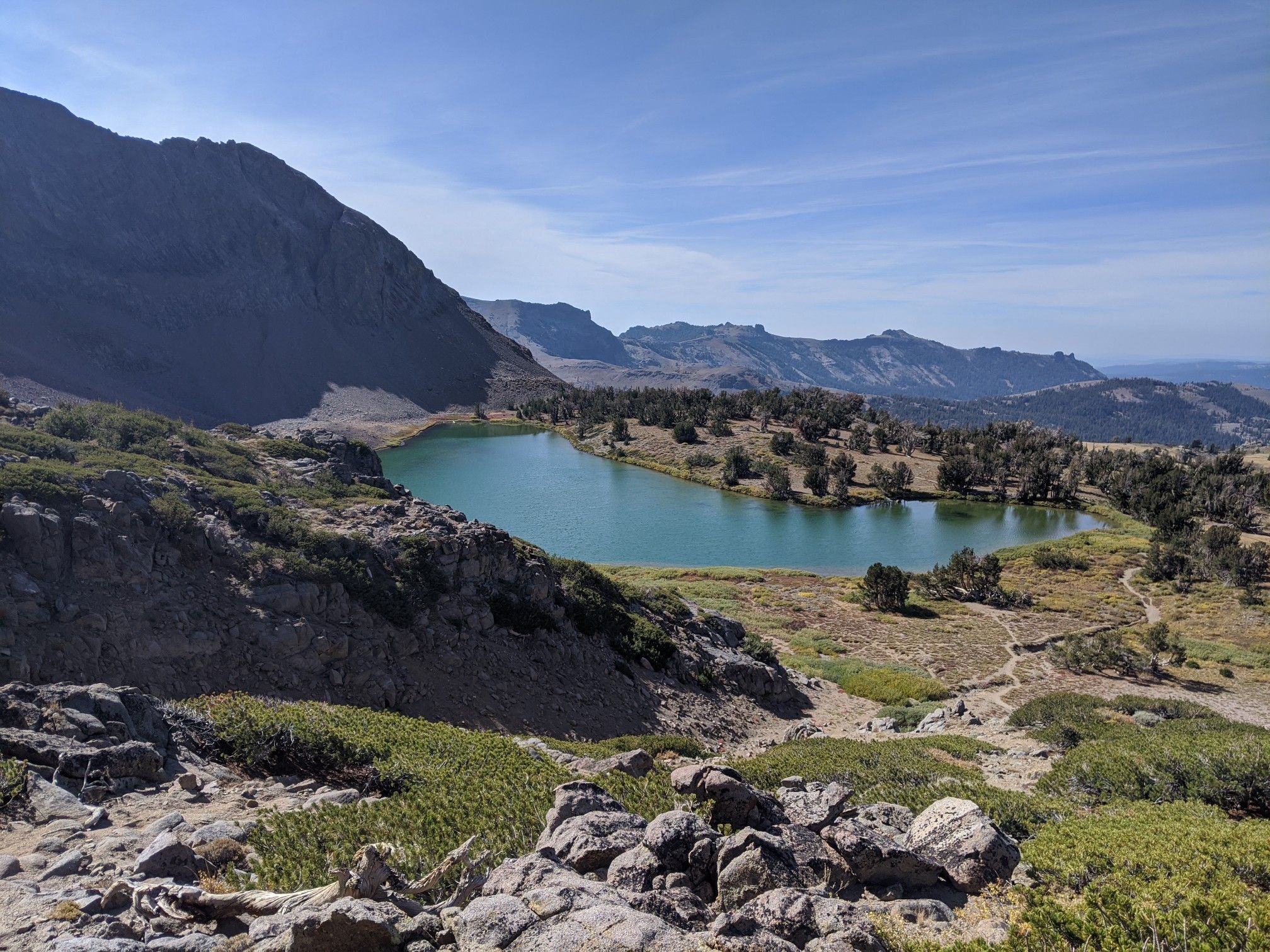 Bright sunny day over a turquoise mountain lake surrounded by rocky terrain. - Winnemucca and Round Top Lakes Loop