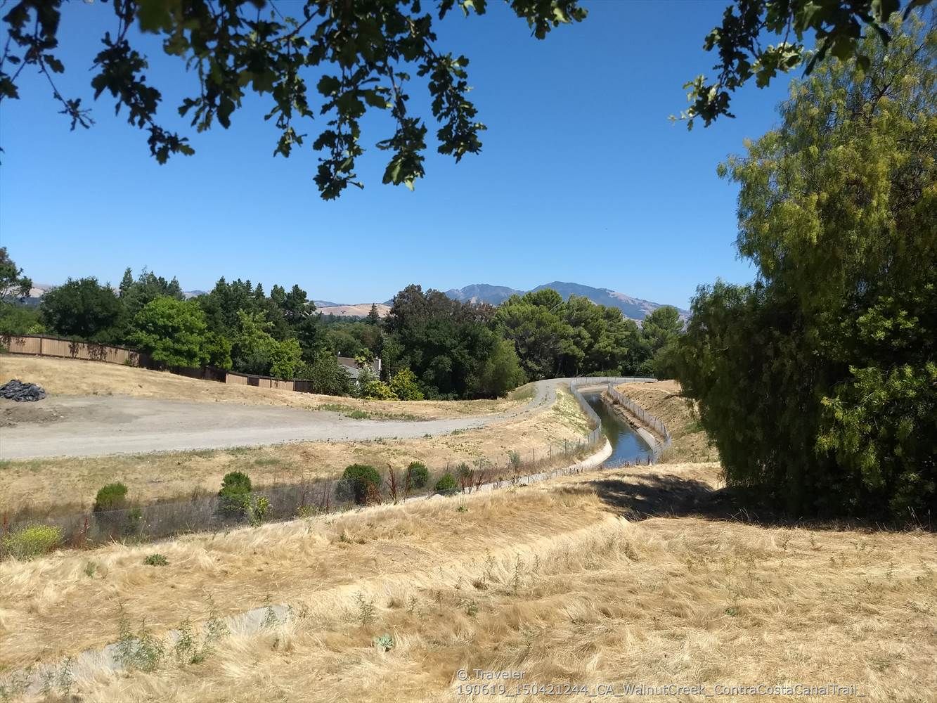 Dry grassy landscape with a winding canal and distant mountains, clear sky. - Contra Costa and Ygnatio Canal Trails Loop