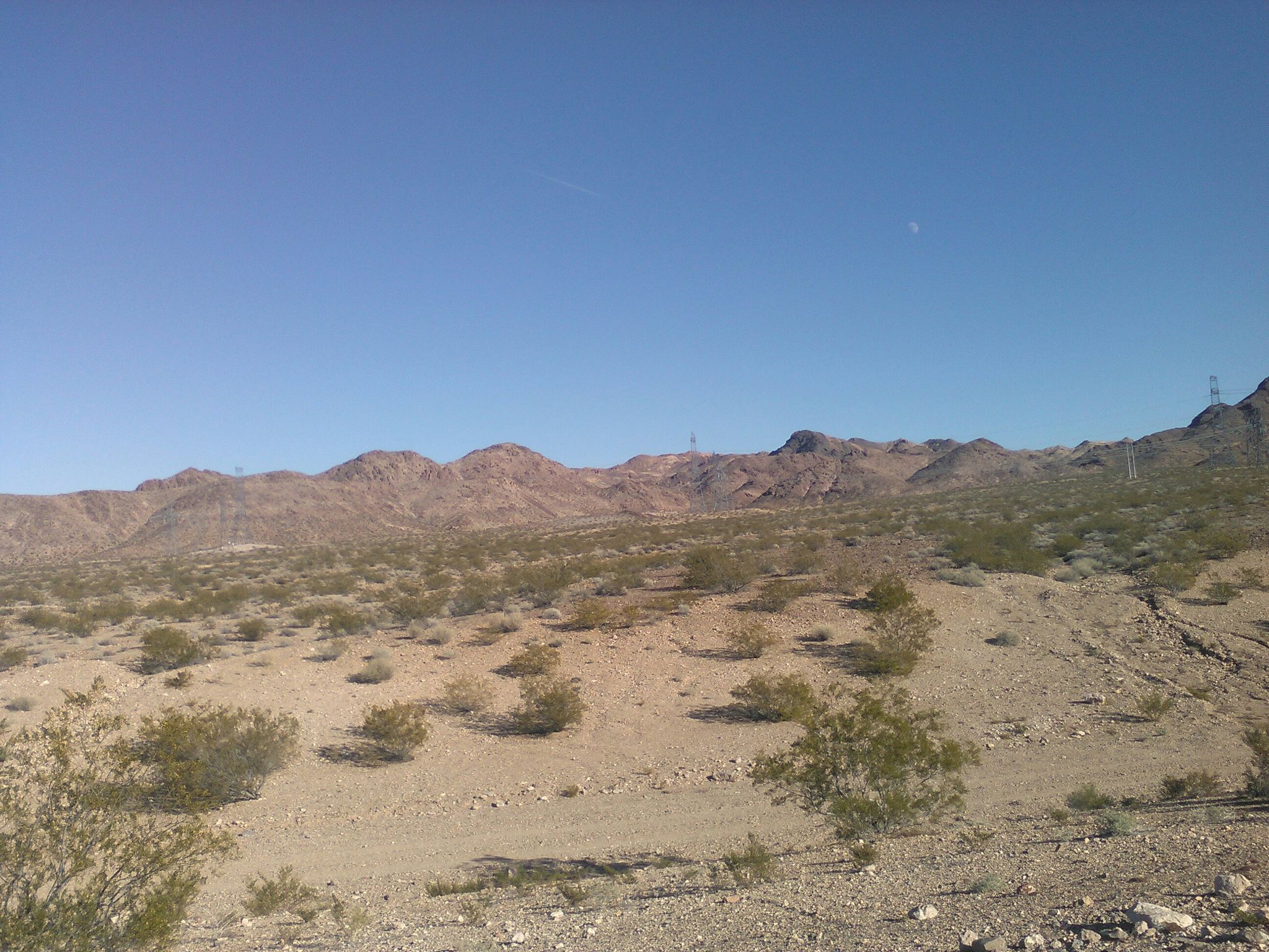 Expansive arid desert landscape with rolling hills and sparse vegetation under clear sky. - Railroad Pass Hotel & Casino – Acacia Park loop from Green Valley High School