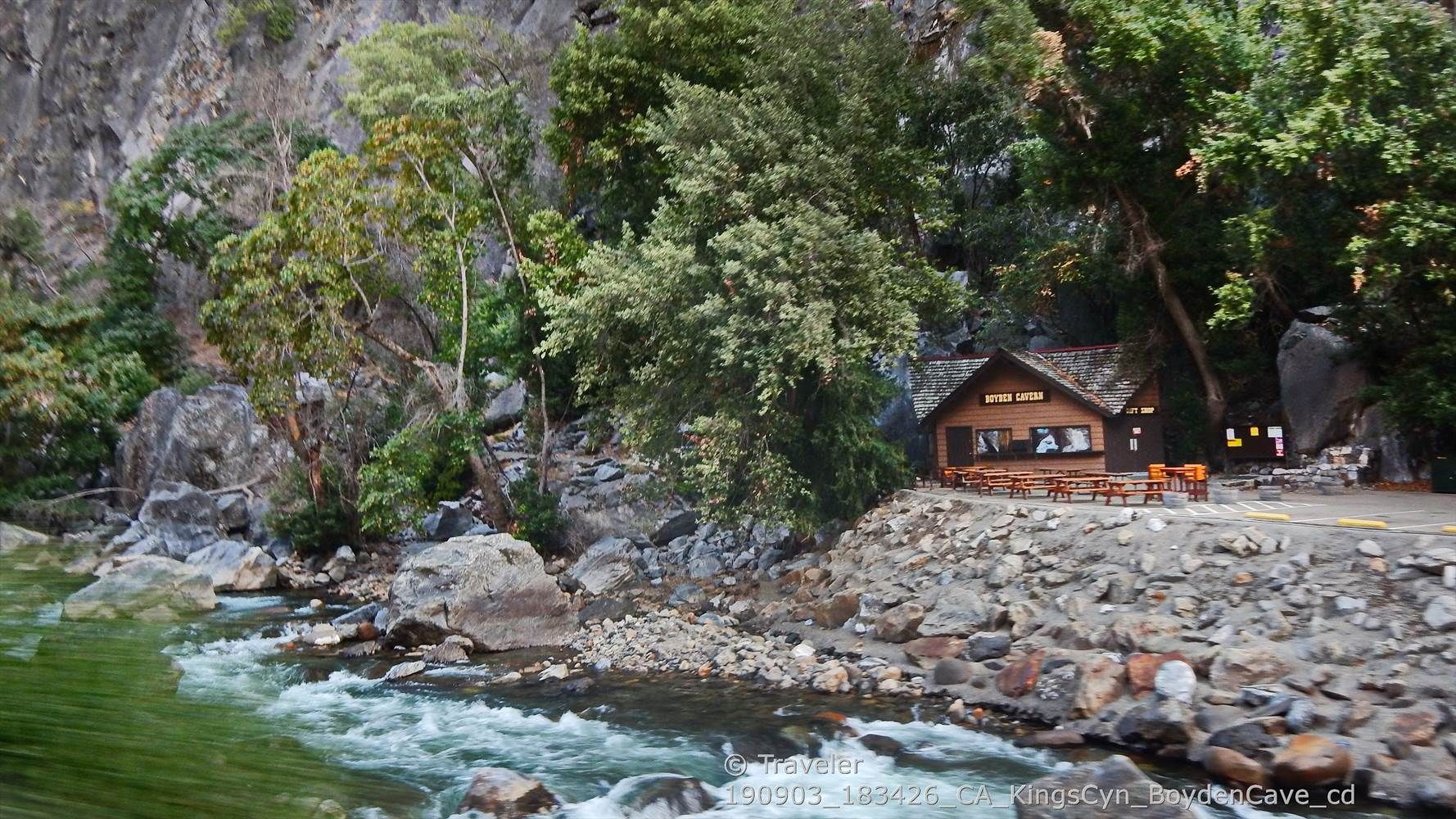 A rustic cabin sits by a rushing river, surrounded by trees and rocks. - Boyden Cavern loop from Boyden Cavern