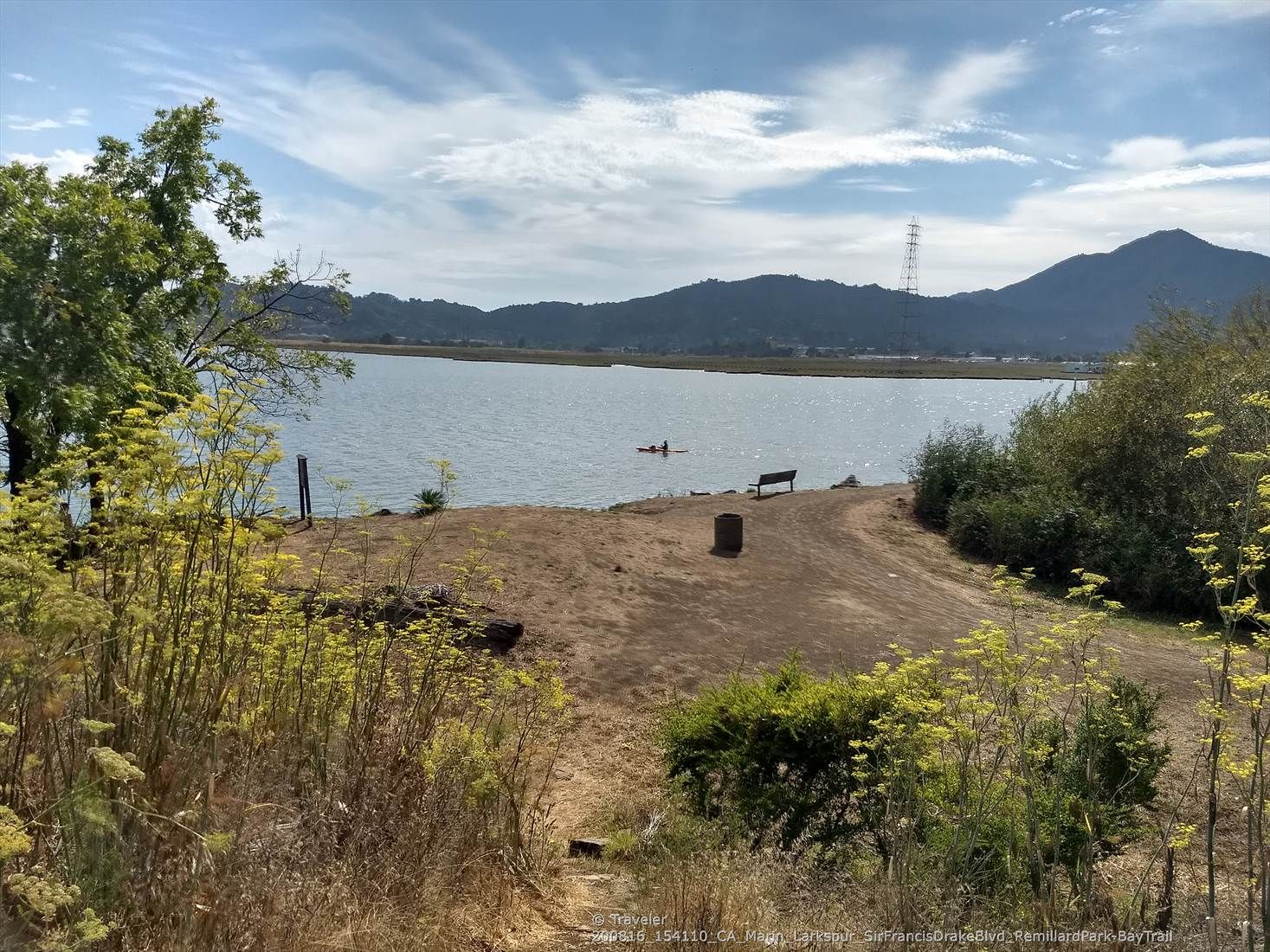 Two people swim in calm water, with a bench and distant mountains. - Horse Hill Bike Path – Sausalito Path loop from Richmond