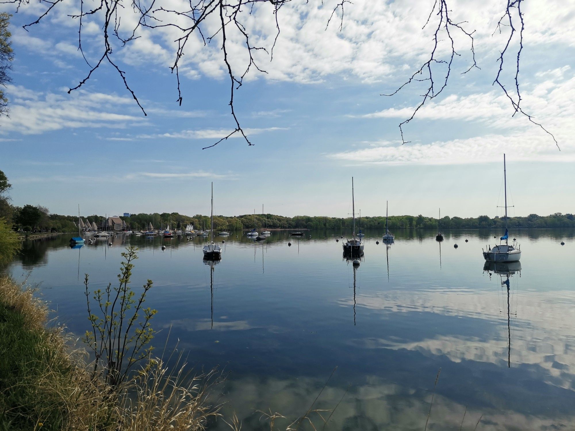 Sailboats on a calm lake under a bright, partly cloudy sky. - Grand Rounds National Scenic Byway