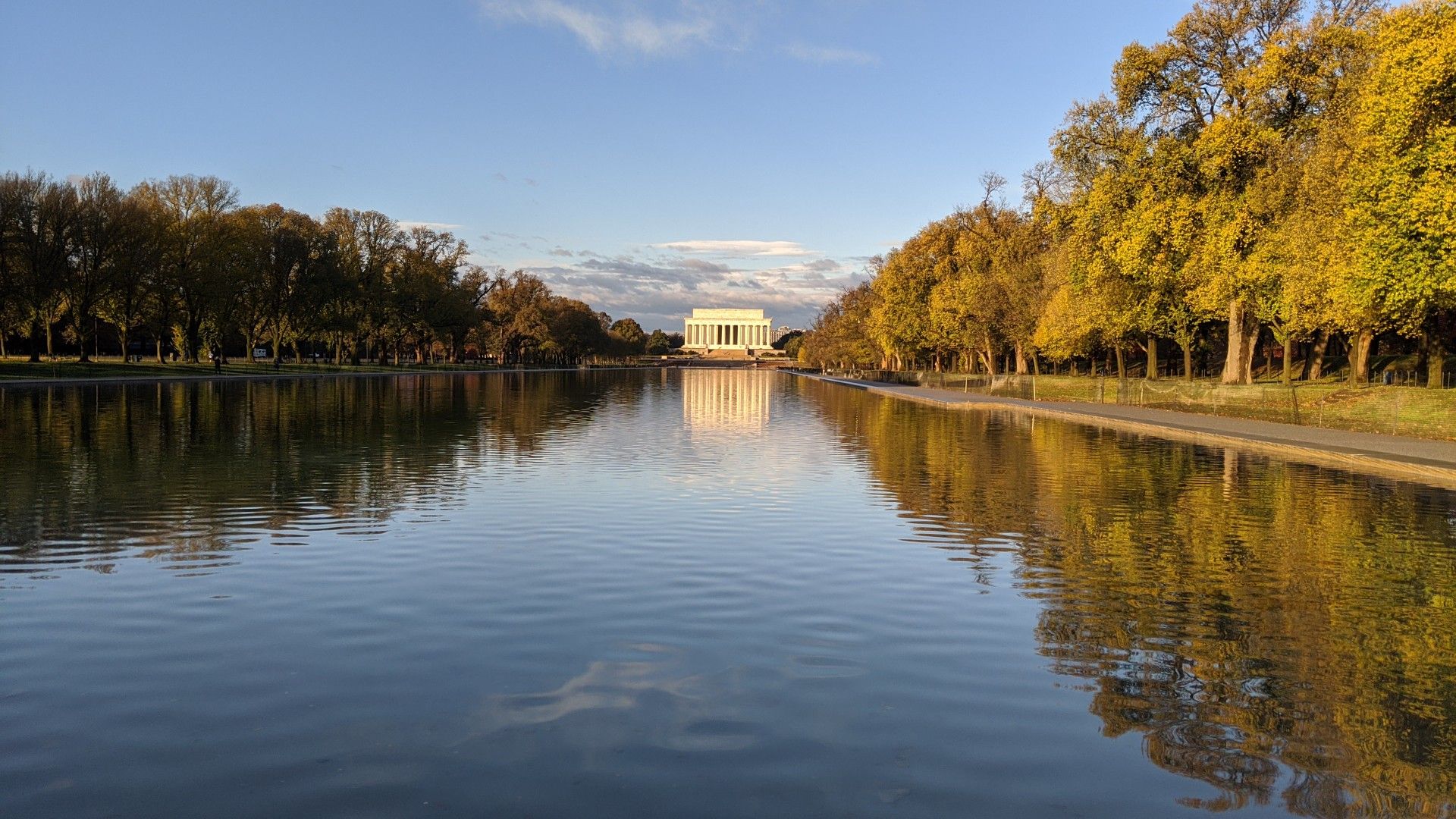 White building reflecting in water, golden trees, clear blue sky. - Lincoln Memorial – Washington Monument loop from Arlington
