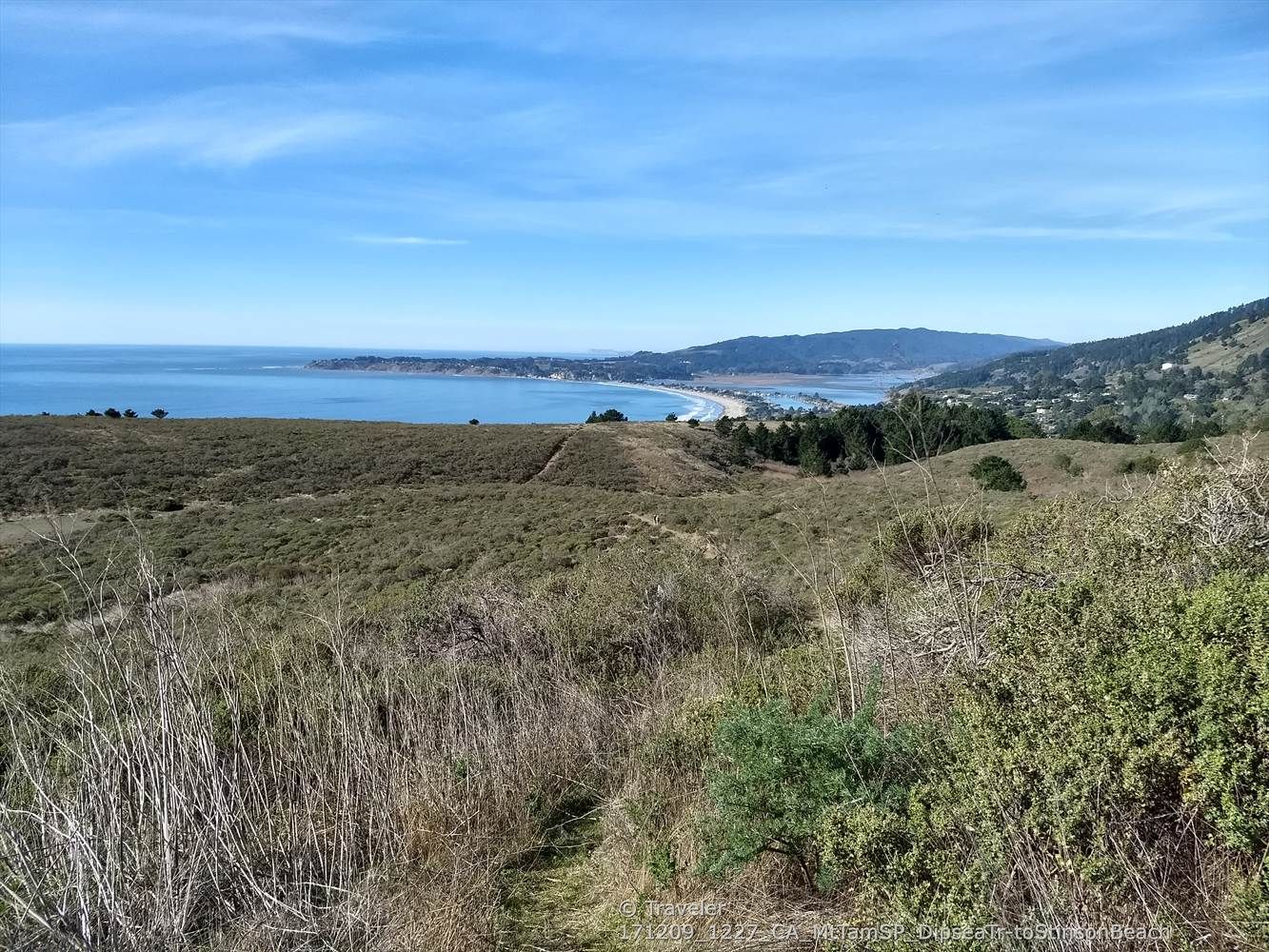 Expansive view of a sunny coastal landscape with ocean and hills. - Dipsea Trail