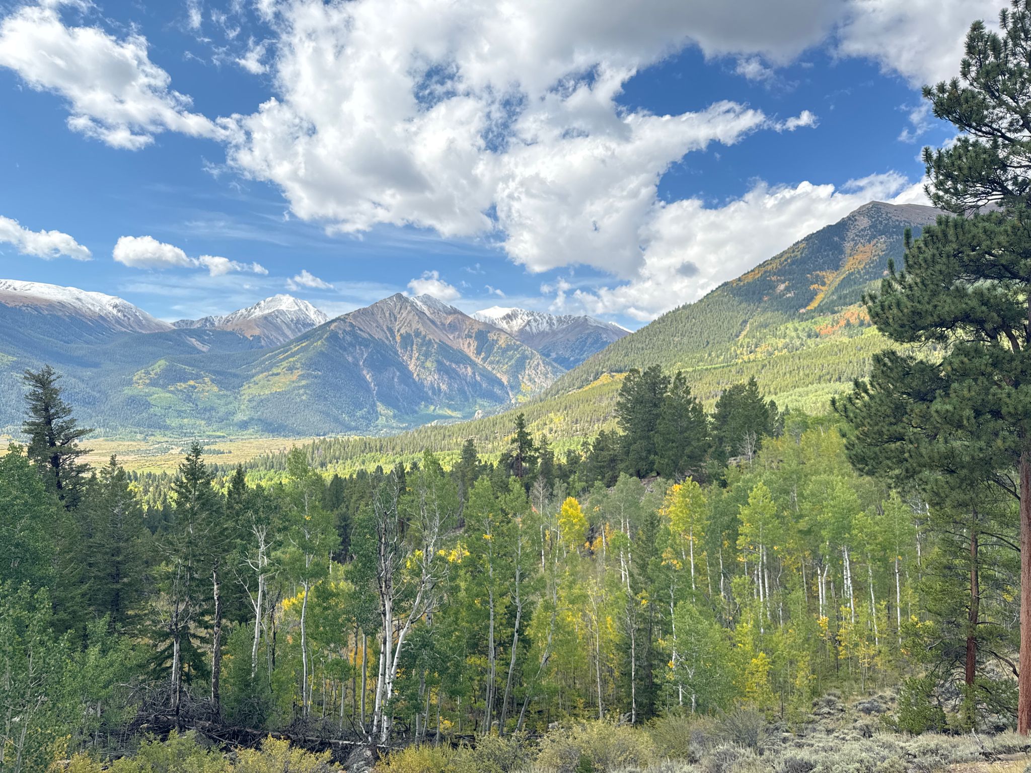 A vibrant mountain valley with green and yellow trees and snowy peaks. - Beach access – Mount Elbert Trailhead loop from Mount Elbert Forebay