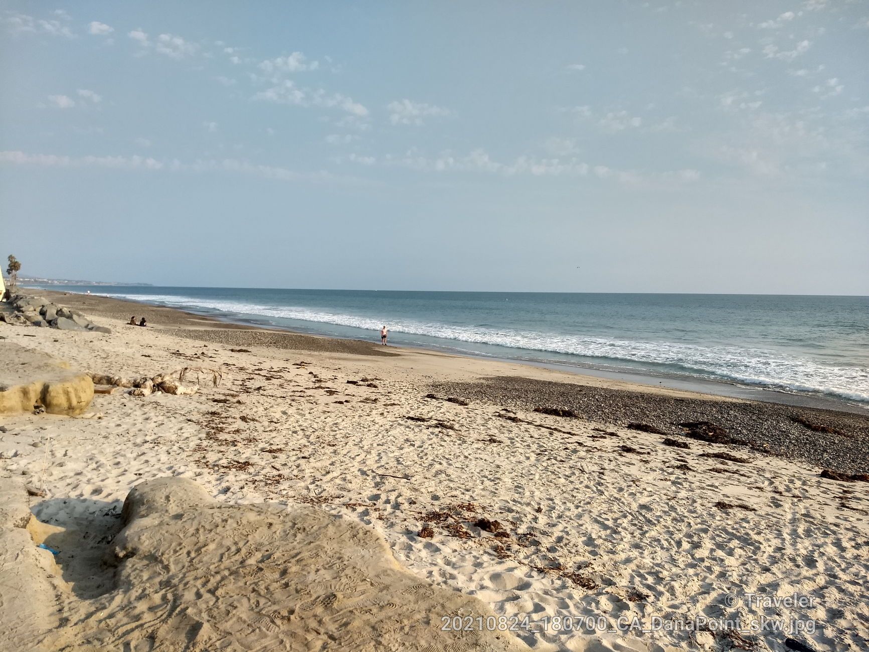 A wide sandy beach meets the ocean with gentle waves under a hazy sky. - San Juan Creek Trail – Doheny State Beach loop from Laguna Niguel/Mission Viejo