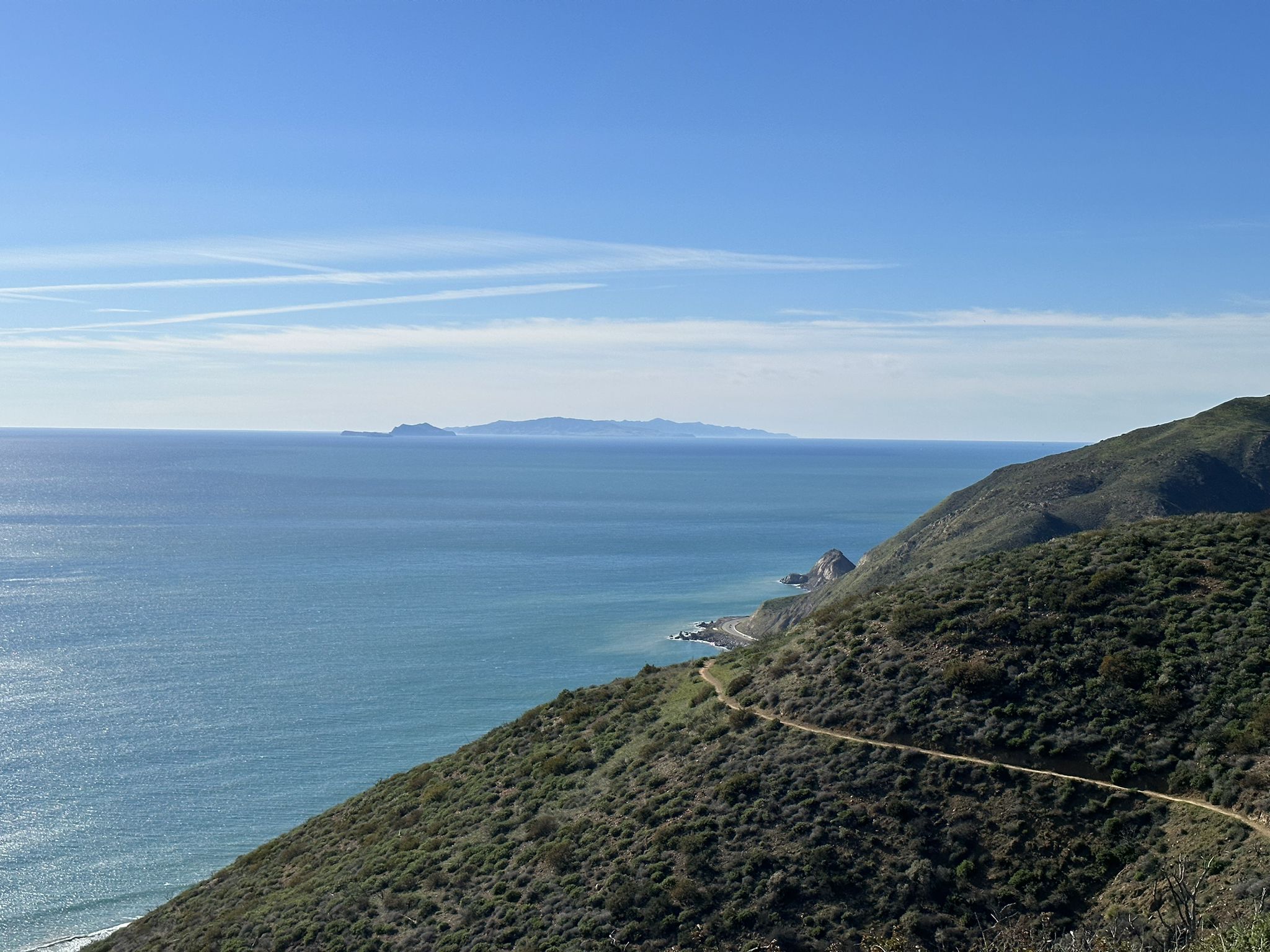 Bright sunny view of blue ocean, distant islands, and green coastal mountains. - Ray Miller Backbone Trail to Overlook Trail