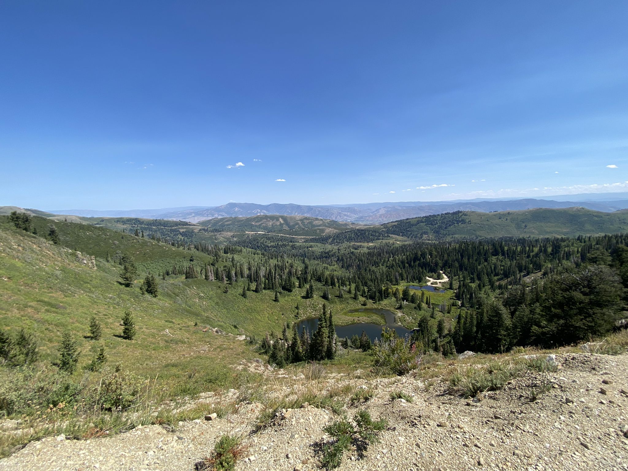 Vast mountain landscape with a small lake, green hills, and clear blue sky. - Wasatch Skyline Drive OHV Route