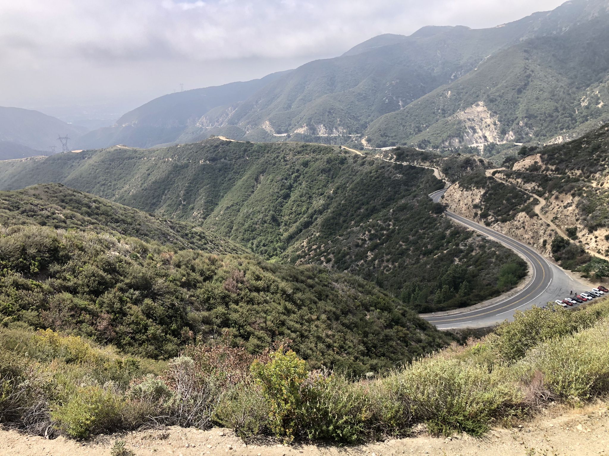 Winding road through green, hazy mountains under a cloudy sky. - Mount Lukens and Josephine Peak Loop