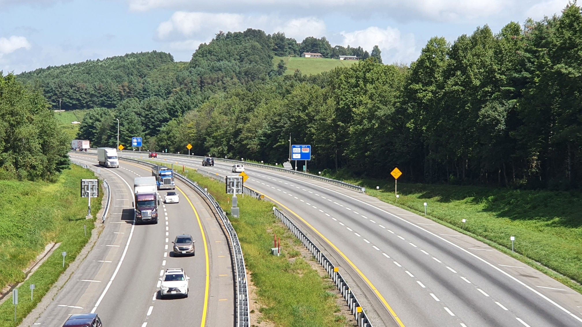 Busy multi-lane highway with cars and trucks, flanked by green hills. - Granite Quarry Overlook – Mount Airy Historic District loop from Gods Acre Cemetery