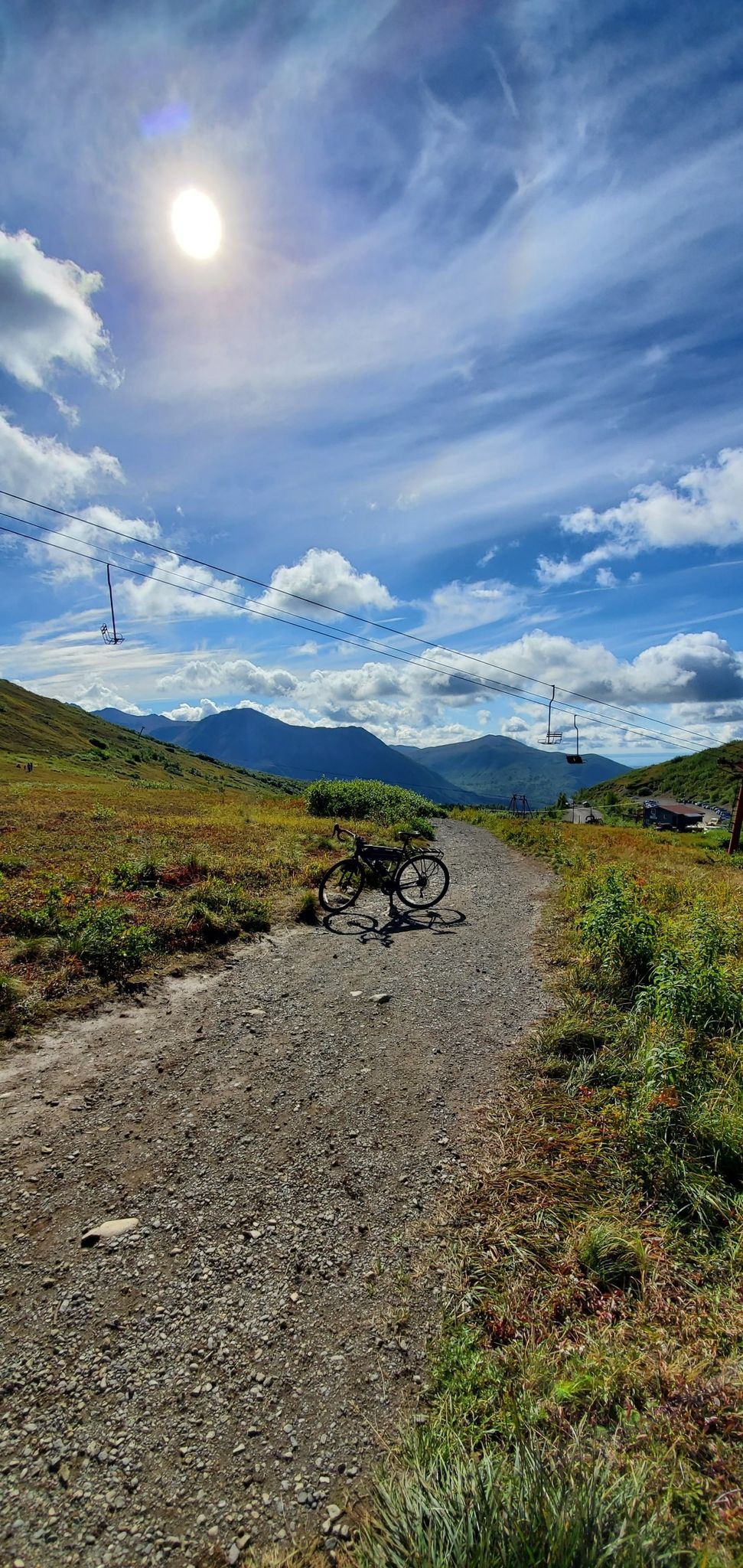 Bicycle resting on a dirt path under a bright, partly cloudy sky. - Rendezvous Peak and Mount Gordon Lyon Loop