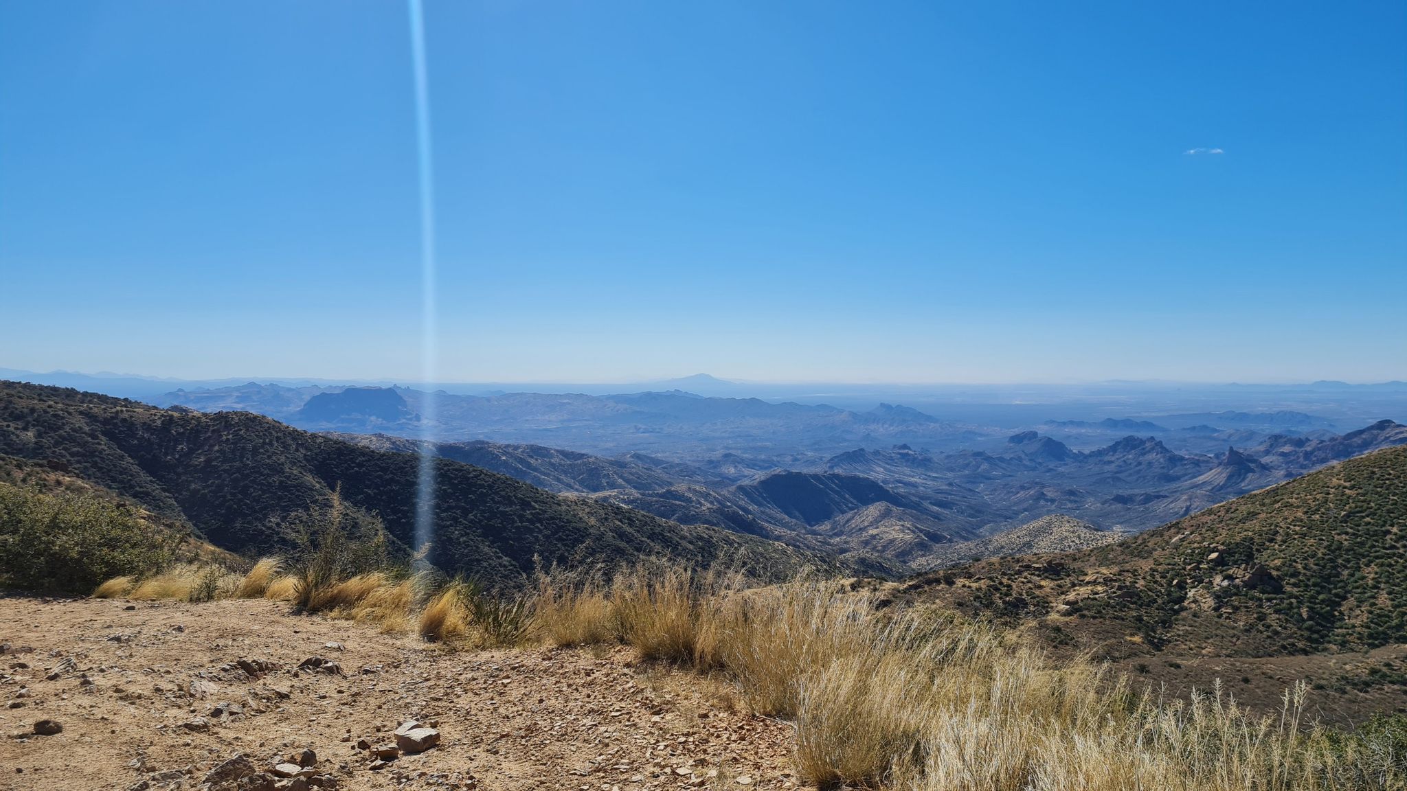 Vast mountain range under a clear, bright sky with dry grasses in foreground. - Montana Mountain/Queen Valley OHV Trail
