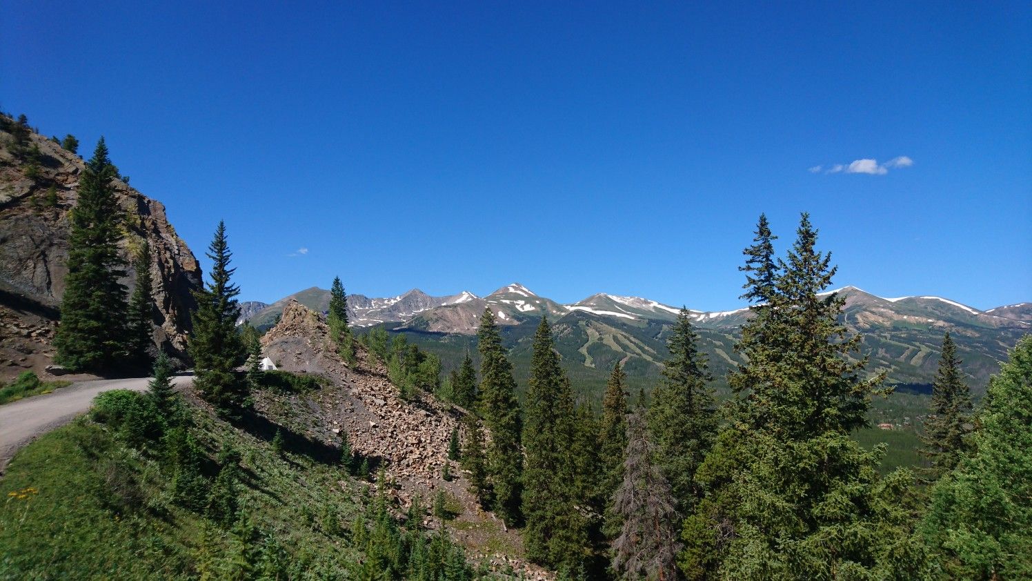 Scenic mountain vista with a winding dirt road and distant snow-capped peaks. - Baker's Tank Trail and Boreas Pass Loop