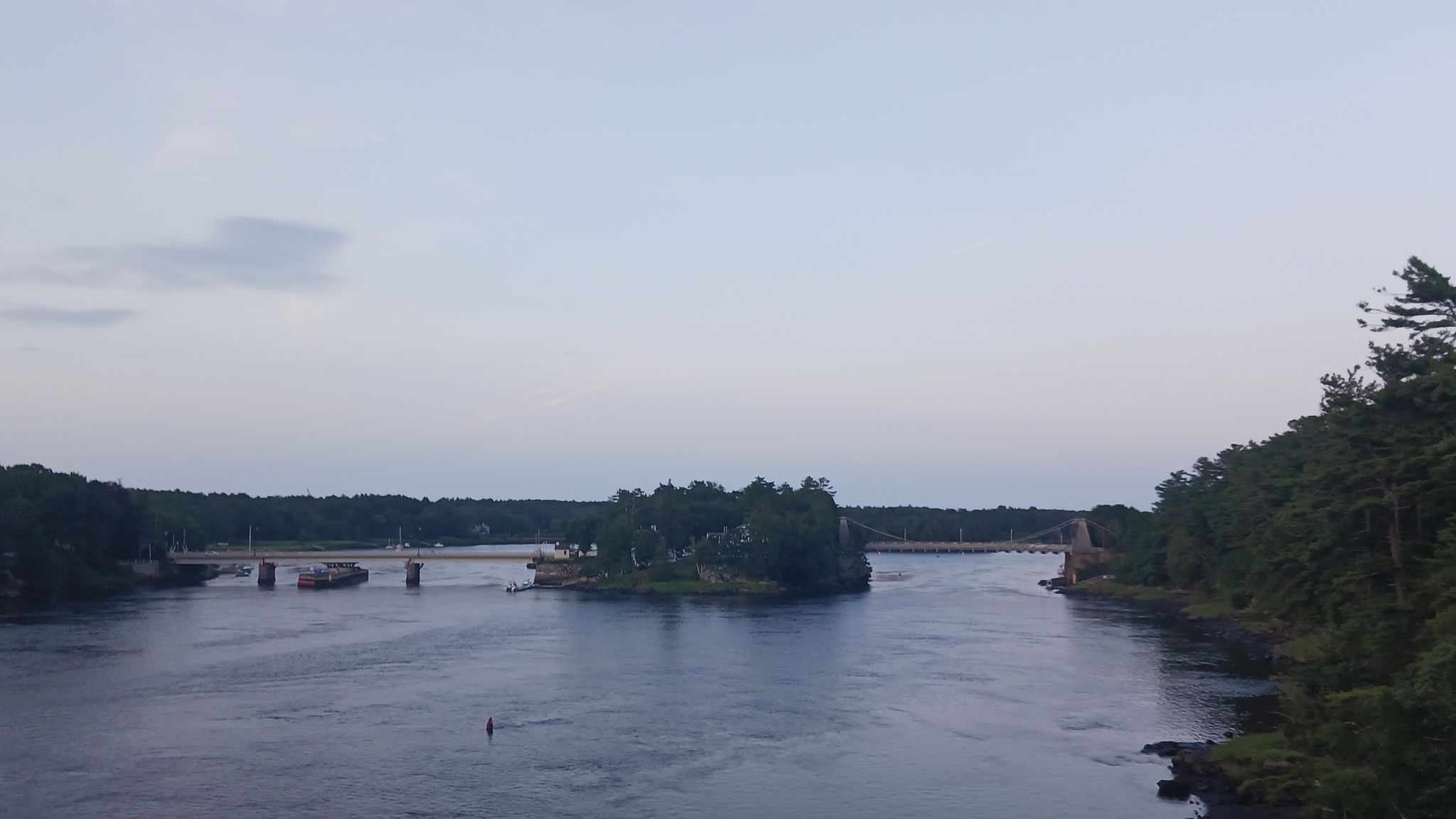 Wide river with a wooded island and distant bridges under a soft sky. - Chain Bridge and Deer Island – John Greenleaf Whittier Bridge loop from Amesbury