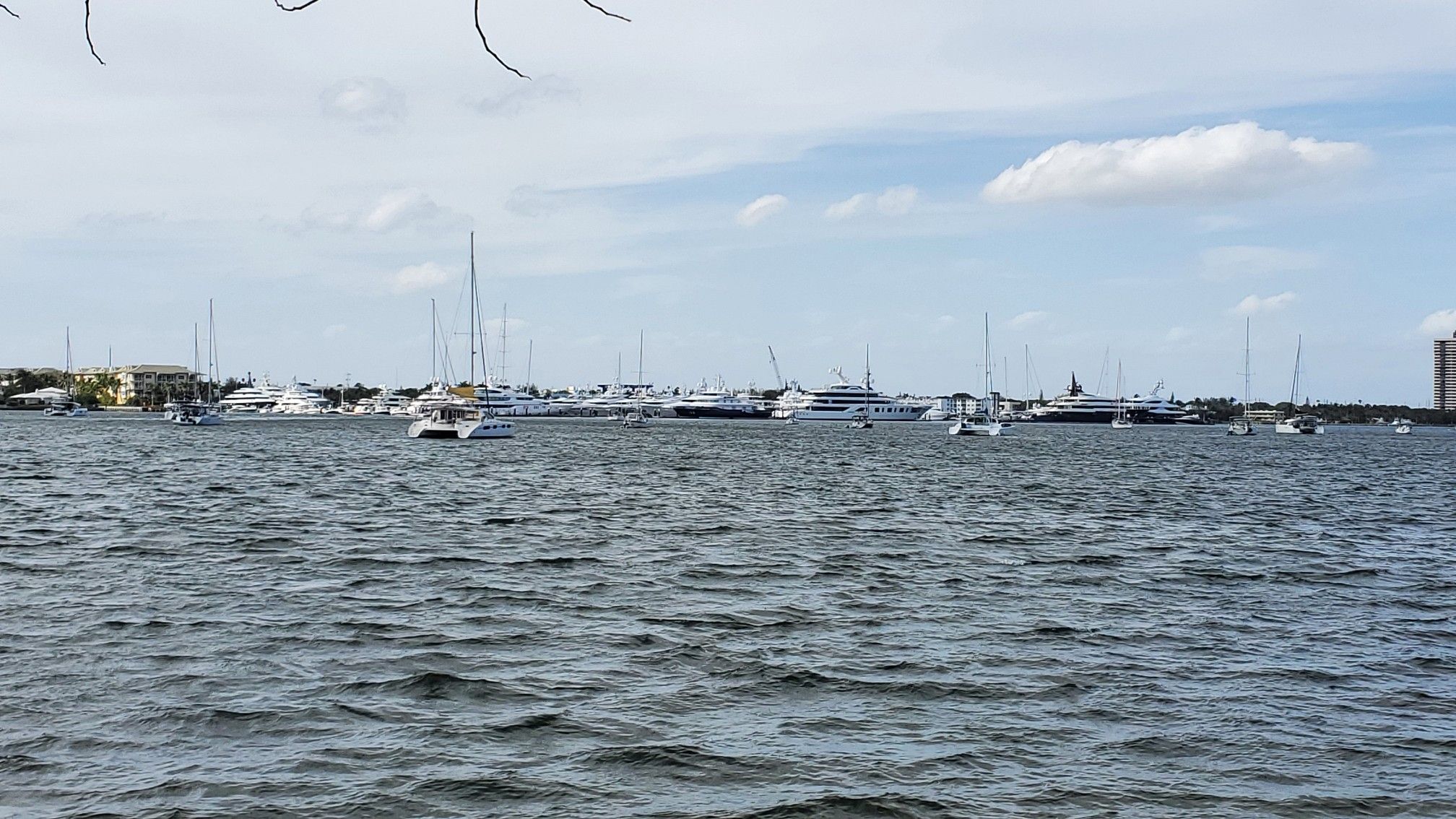 Many boats and yachts docked in a wide body of water under a cloudy sky. - Lake Trail – Lake Trail loop from West Palm Beach
