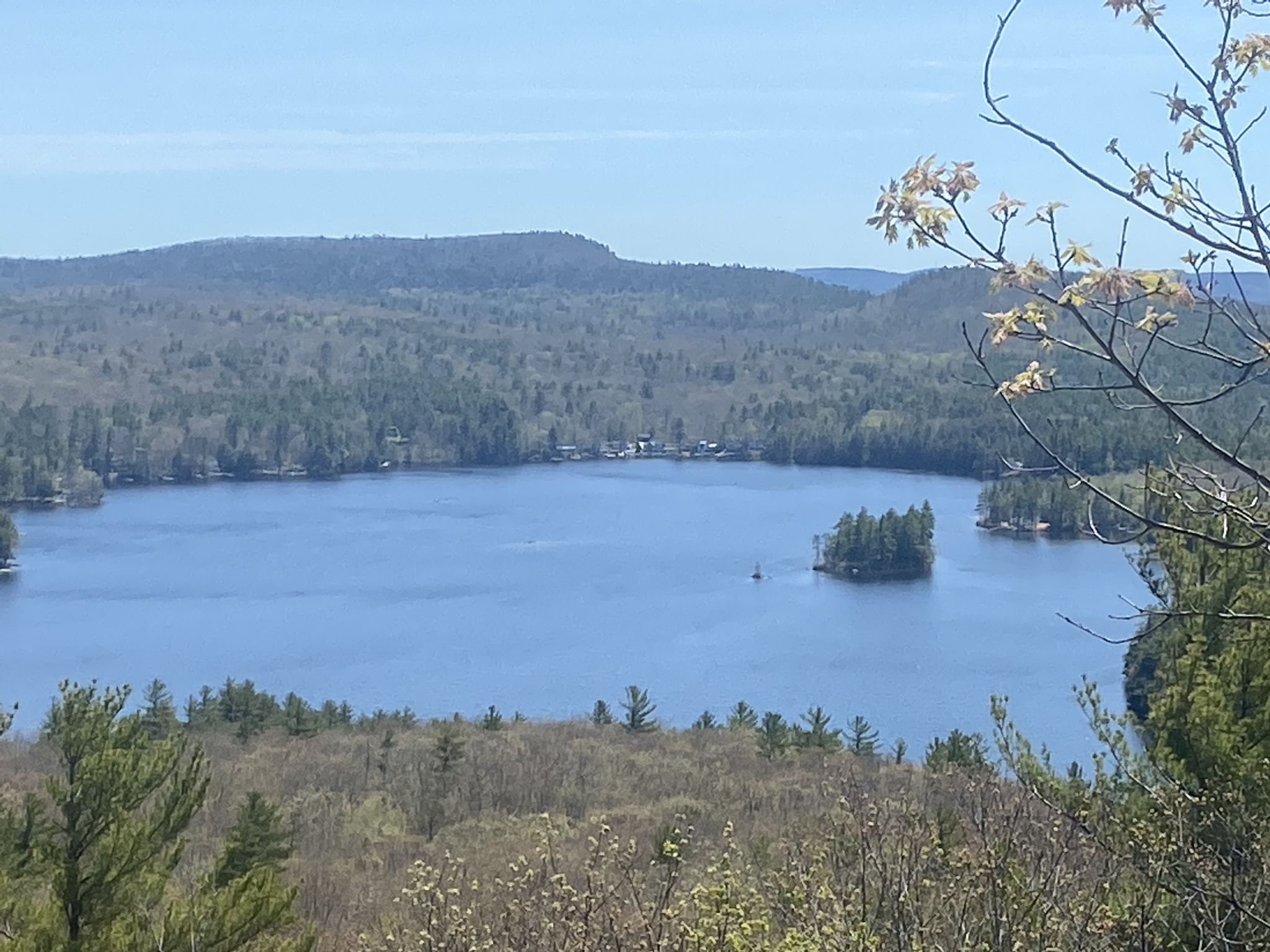 Bright aerial view of a blue lake, forested islands, and distant mountains. - Mount Shannon Yellow Trail Loop