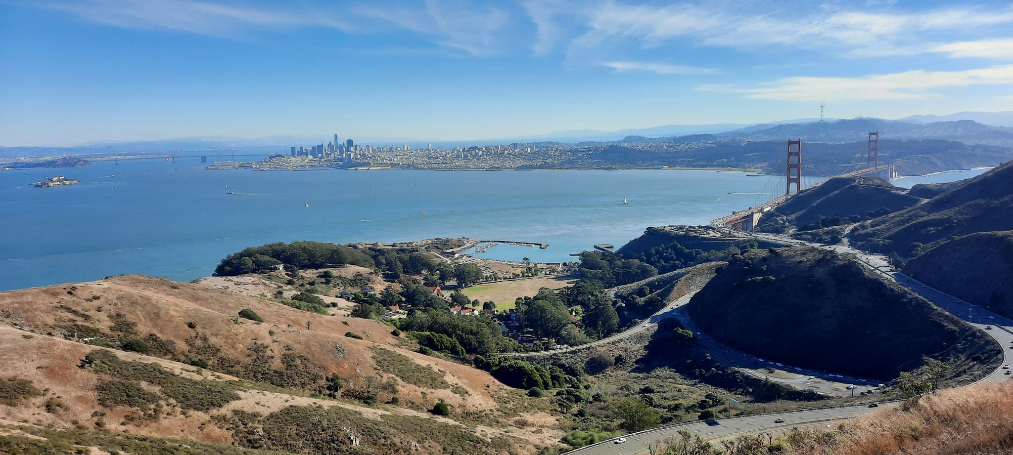 Panoramic view of a bay, city skyline, and bridge from rolling hills. - Julian Trail 🌿 Marin Headlands – Gerbode Valley Trailhead loop from Sausalito
